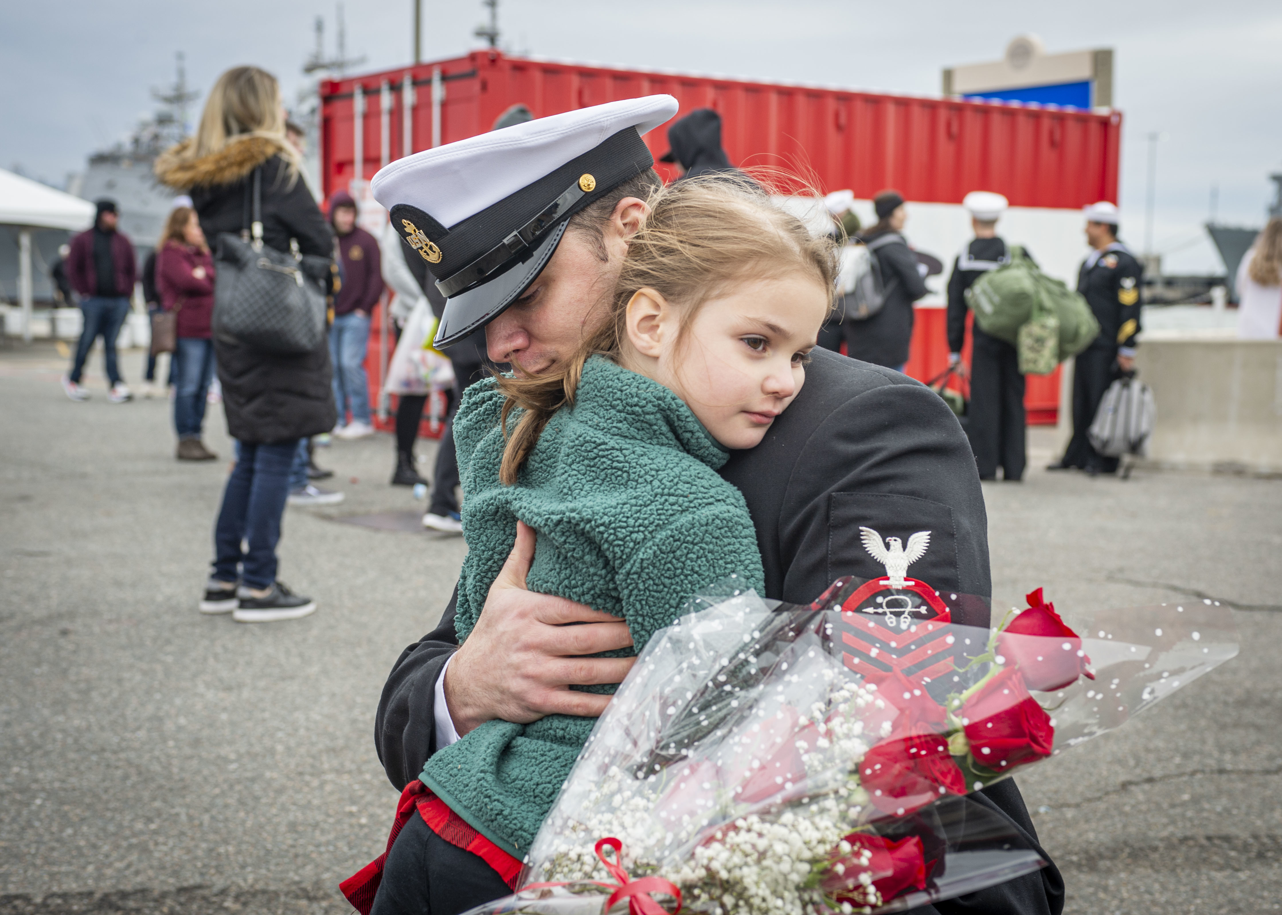 Chief Sonar Technician (Submarine) Samuel Dunn, assigned to the Virginia-Class fast-attack submarine USS Washington (SSN 787), embraces his daughter during the boat’s homecoming at Naval Station Norfolk, Feb. 27, 2022.