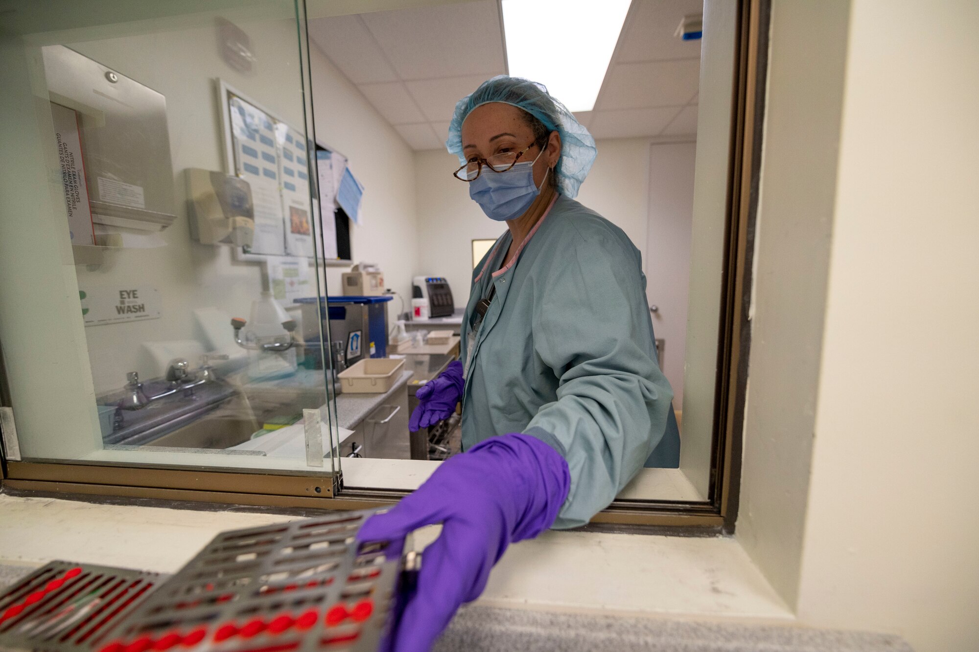 Tabitha Womack, 4th Operational Medical Readiness Squadron dental assistant, places washed instruments in the clean room at Seymour Johnson Air Force Base, North Carolina, Feb. 24, 2022. The sanitizing rooms are separated between a dirty and clean room to maintain proper sanitizing standards and nothing is contaminated before an operation. (U.S. Air Force photo by Airman 1st Class Kevin Holloway)