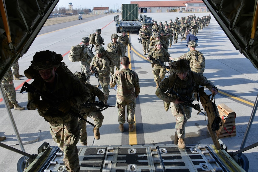 Paratroopers board a C-130 aircraft.