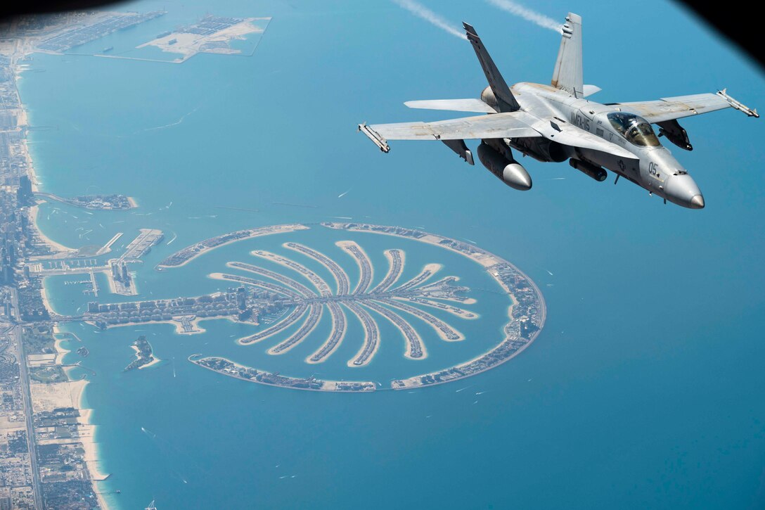 An airborne jet over a coastline.