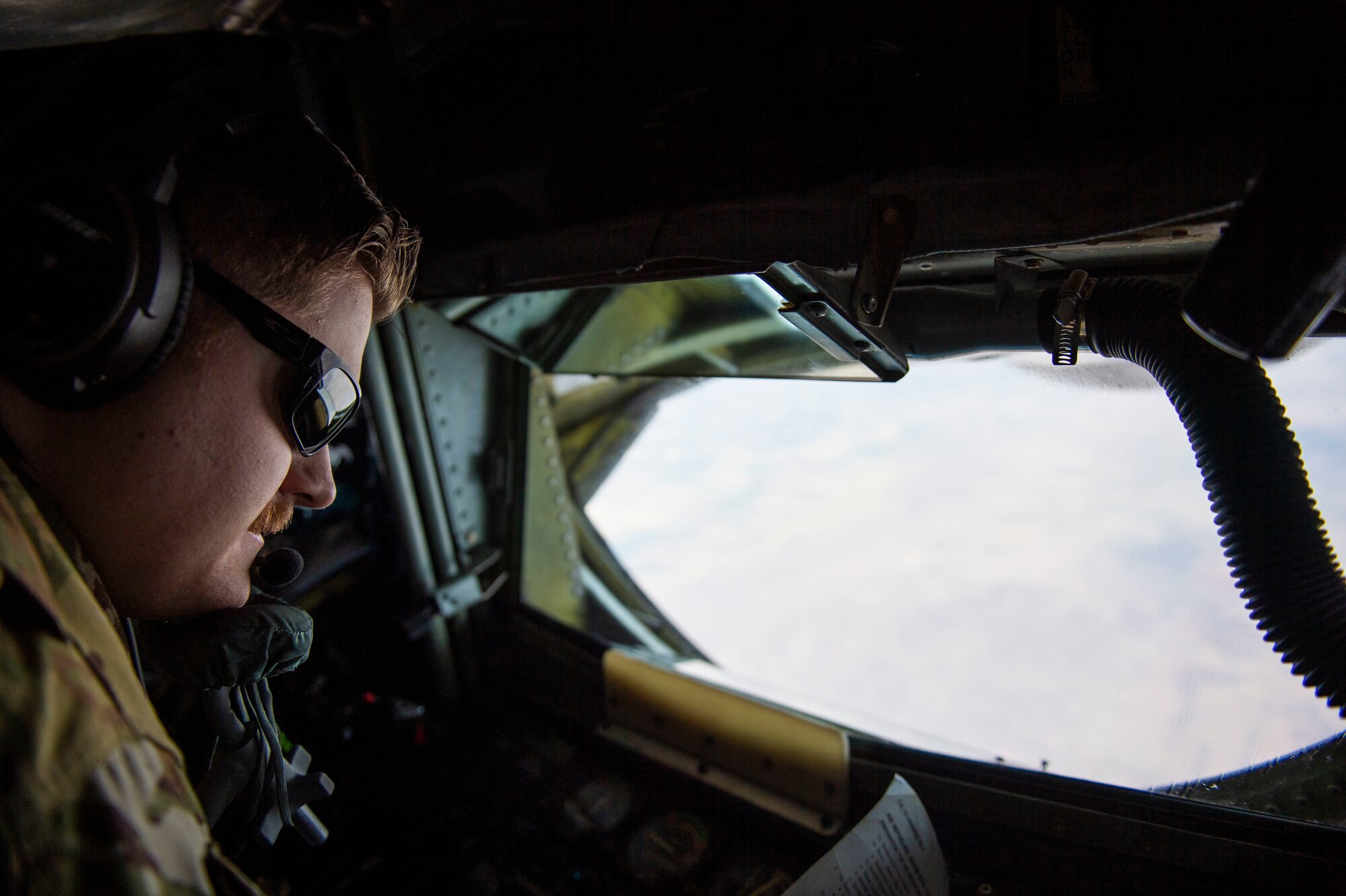 U.S. Air Force Senior Airman Dillon Tucker, a boom operator assigned to the 91st Air Refueling Squadron, prepares to refuel an aircraft over New Mexico, Feb. 22, 2022.