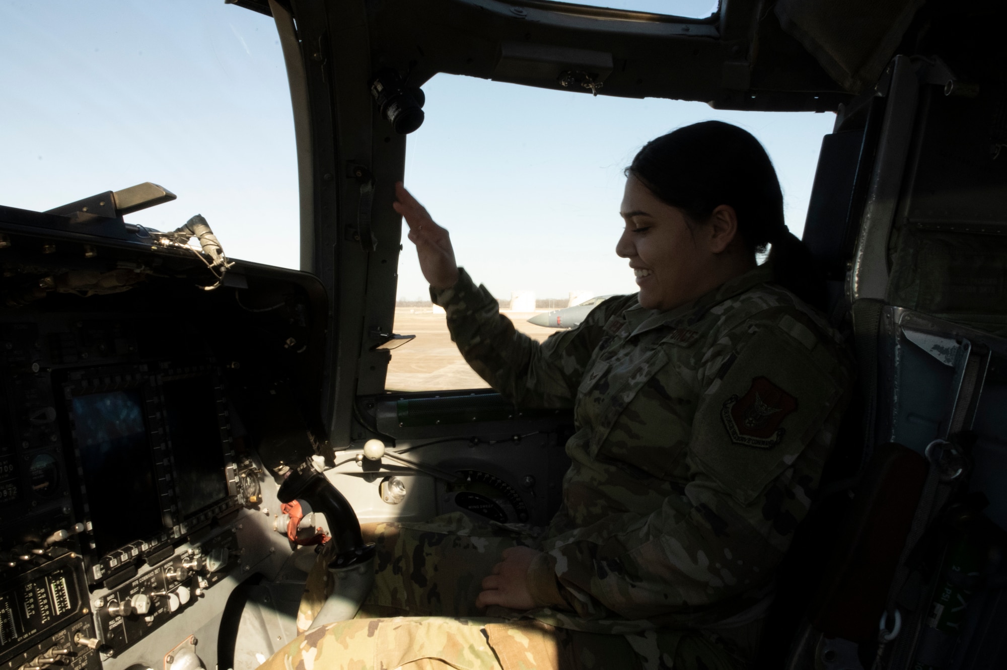An Airman sits inside an aircraft.