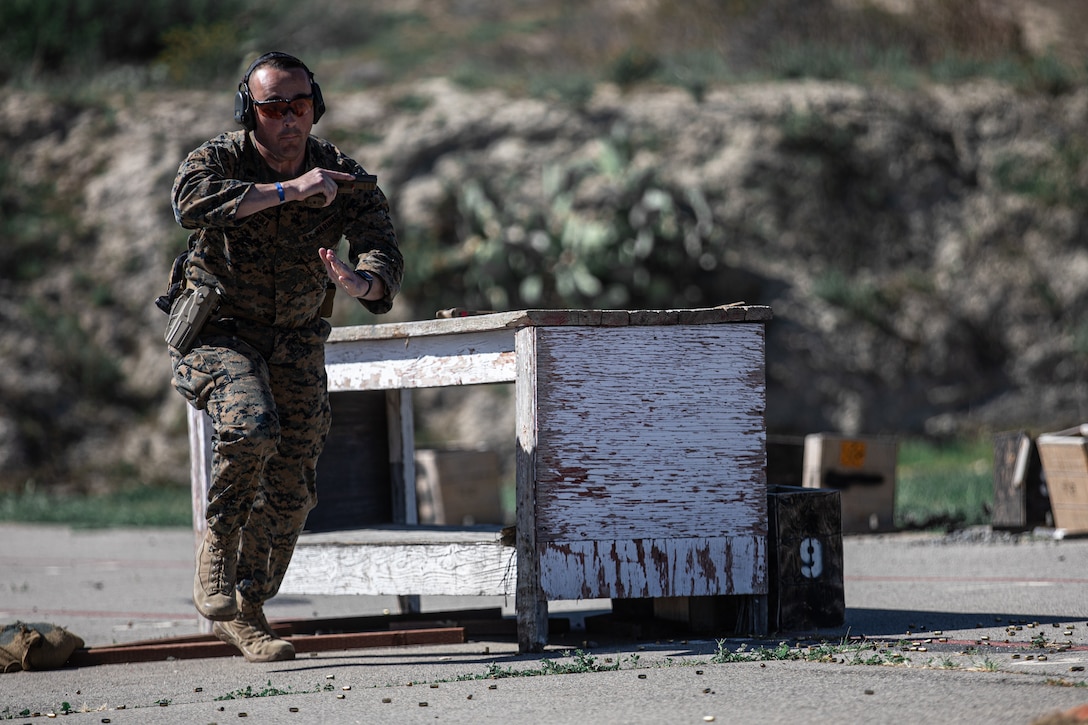 U.S. Marine Corps Staff Sgt. a drill instructor with Charlie Company, 1st Recruit Training Battalion, competes in the pistol team match during Marine Corps Marksmanship Competition West (MCMC-W) at Camp Pendleton, Calif., Feb. 18, 2022. MCMC-W provides an opportunity to refine the fundamental skills that make a Marine lethal on the battlefield and able to deliver lethal force in a dynamic environment. (U.S. Marine Corps photo by Cpl. Anthony D. Pio)