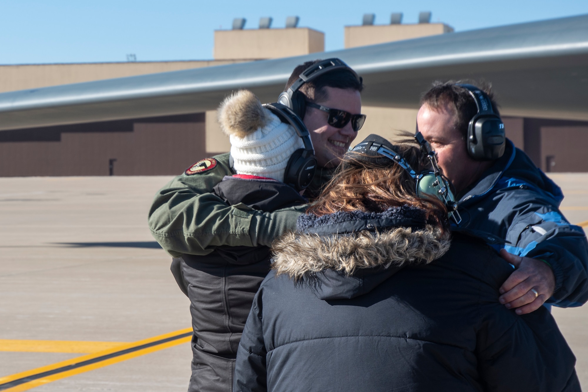 Master Sgt. Joshua Upton embraces friends and family following an incentive flight in a B-2 Spirit stealth bomber at Whiteman Air Force Base, Missouri, Jan. 9, 2022. Upton, the wing's Maintainer of the Year, earned his ride in the aircraft due to his exemplary work throughout 2021. (U.S. Air National Guard photo, 131st Bomb Wing Public Affairs)