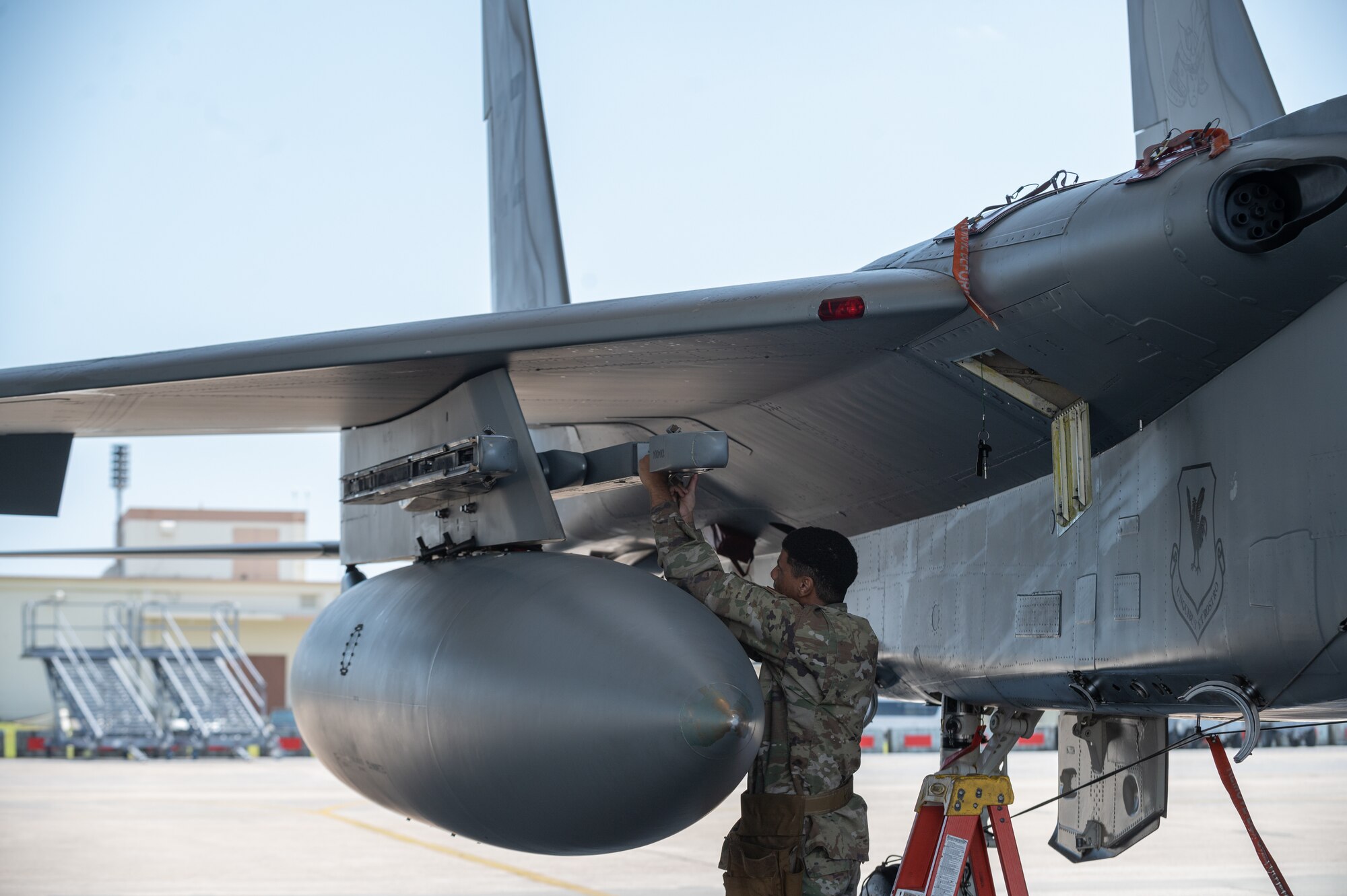 Airman performs maintenance on F-15