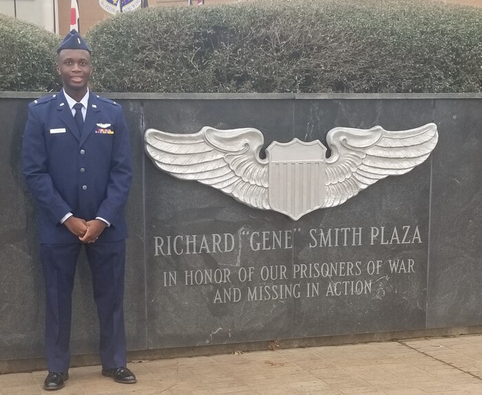 Minority pilot stands next to a memorial after completing undergraduate pilot training at Columbus Air Force Base, Miss.