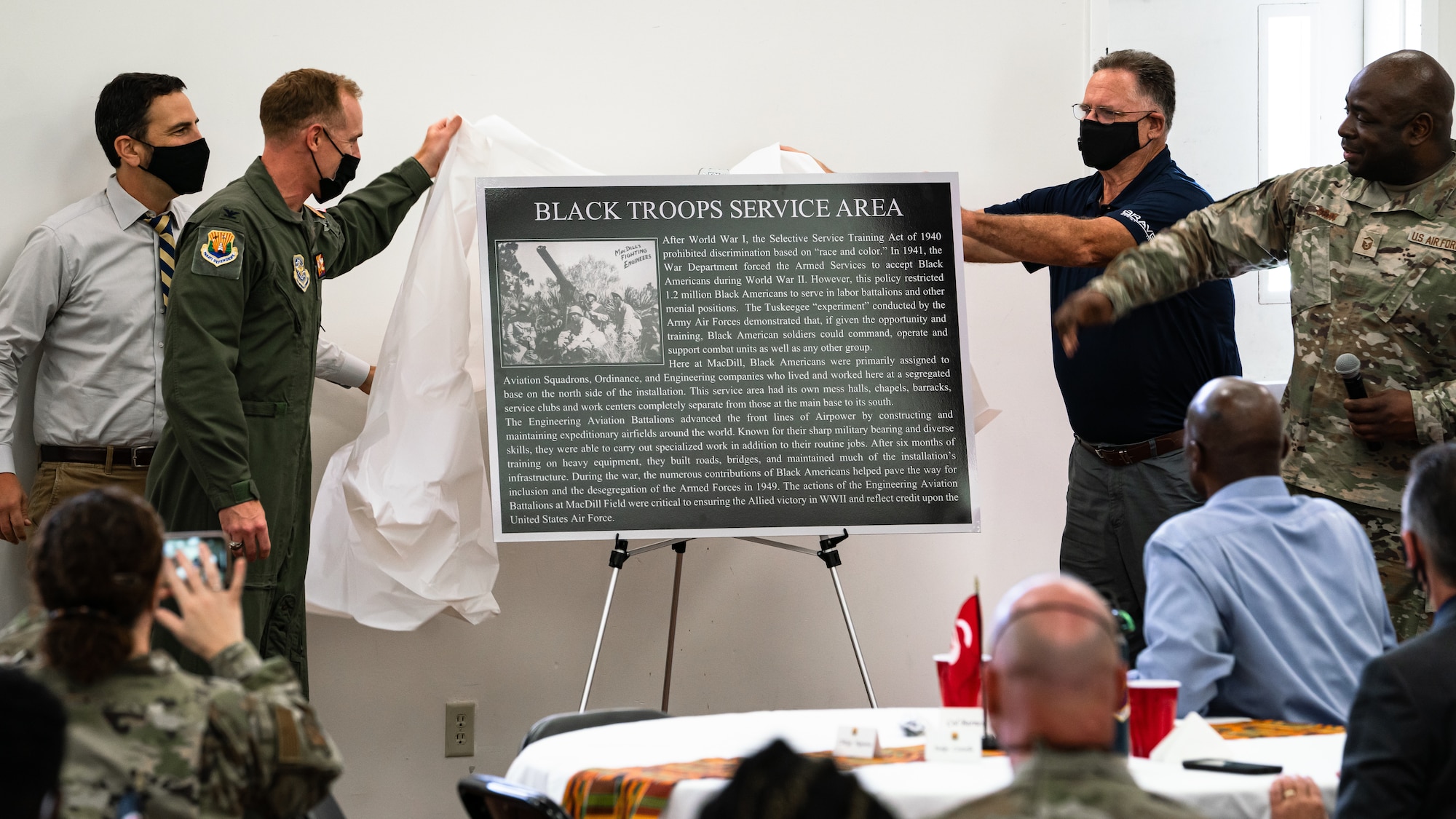 The 6th Air Refueling Wing team responsible for the heritage marker project unveils a “Black Troops Service Area” heritage marker during a Black History Month commemorative luncheon at MacDill Air Force Base, Florida, Feb. 25, 2022. The heritage marker formally recognizes the service of thousands of African Americans who served in engineer aviation battalions during World War II. The efforts of these battalions, which trained at MacDill, expedited the end of the conflict and helped ensure an Allied victory. (U.S. Air Force photo by Airman 1st Class Joshua Hastings)