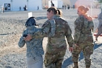 U.S. Air Force Col. Bernadette Maldonado and Lt. Col. April Doolittle, New Jersey Air National Guardsmen assigned to the 108th Wing, walk with an Afghan girl in Liberty Village on Joint Base McGuire-Dix-Lakehurst, N.J., Nov. 8, 2021.