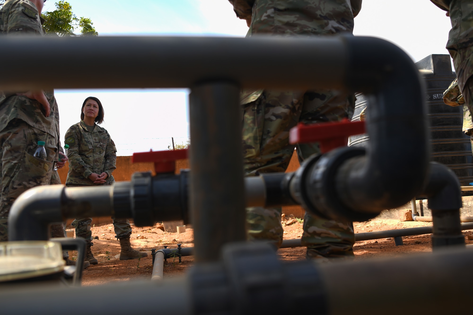 Chief Master Sgt. of the Air Force JoAnne S. Bass talks to Airmen from the 768th Air Expeditionary Base Squadron civil engineering flight (CEF) at Nigerien Air Base 101, Niamey, Dec. 21, 2021. Recently the CEF built a recirculation system for the water stored on the AB 101. The CEF are multi-capable and adaptable team builders, as well as innovative and courageous problem solvers, who demonstrate value in the diversity of thought, ingenuity, and initiative.  (U.S. Air Force photo by Senior Airman Ericka A. Woolever)