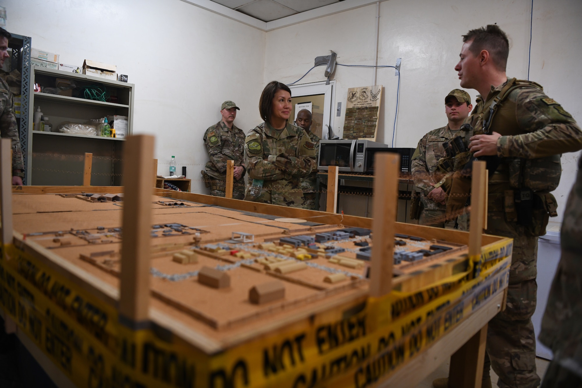 Airman 1st Class Joshua Langham, 768th Air Expeditionary Base Squadron security forces flight member, briefs Chief Master Sgt. of the Air Force JoAnne S. Bass at Nigerien Air Base 101, Niamey, Dec. 21, 2021. Langham used his personal mono-price-delta-mini 3D printer to print new gaskets for AB 101  communication radios. (U.S. Air Force photo by Senior Airman Ericka A. Woolever)