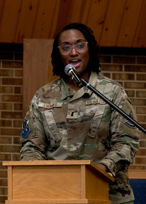 A woman stands at a podium giving a speech