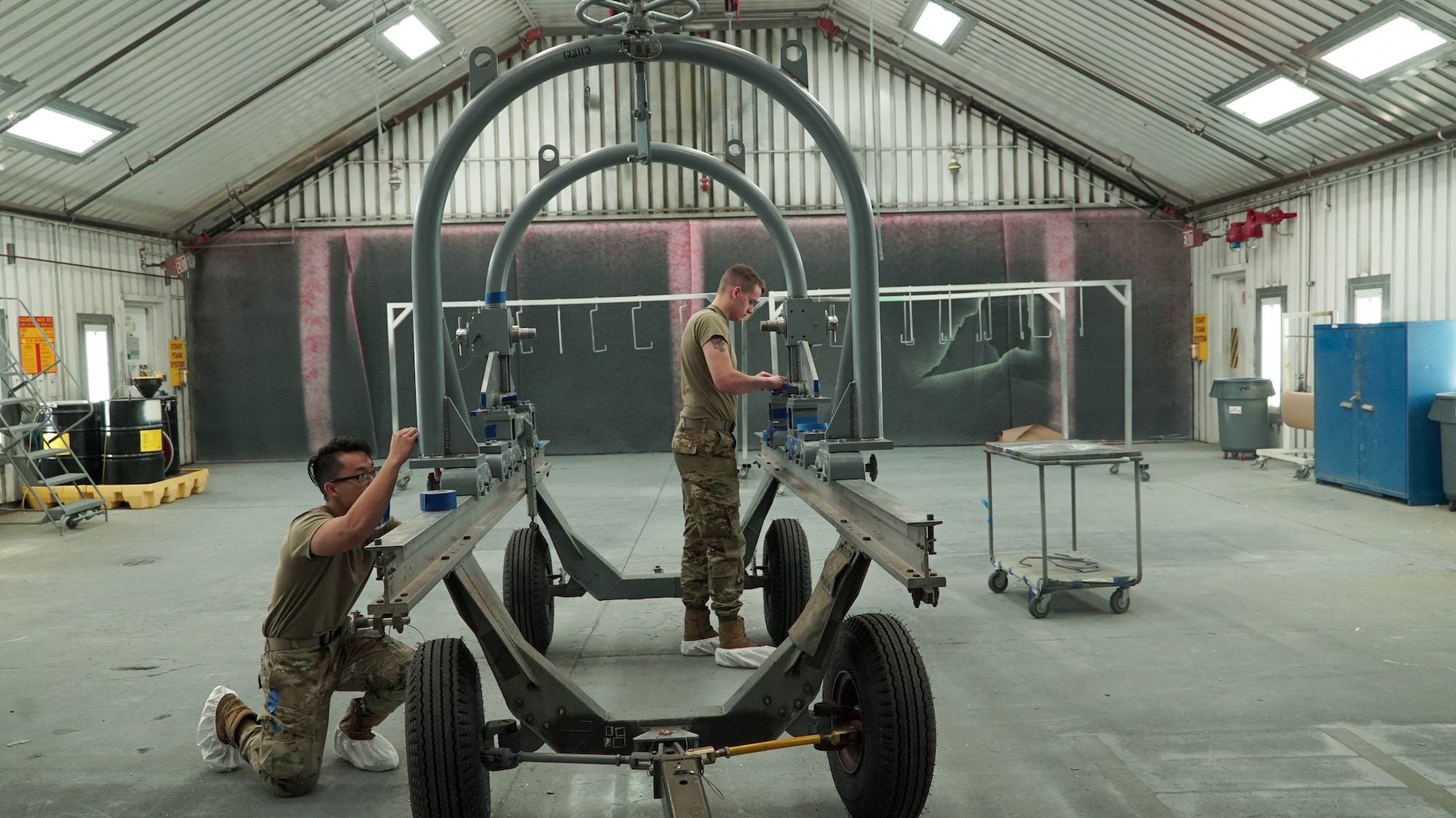 U.S. Air Force Airman 1st Class Evander Esperanza and Airman Grayson Frank apply protective tape to the frame of an F-35 component at the 388th MXS Squadron at Hill Air Force Base.