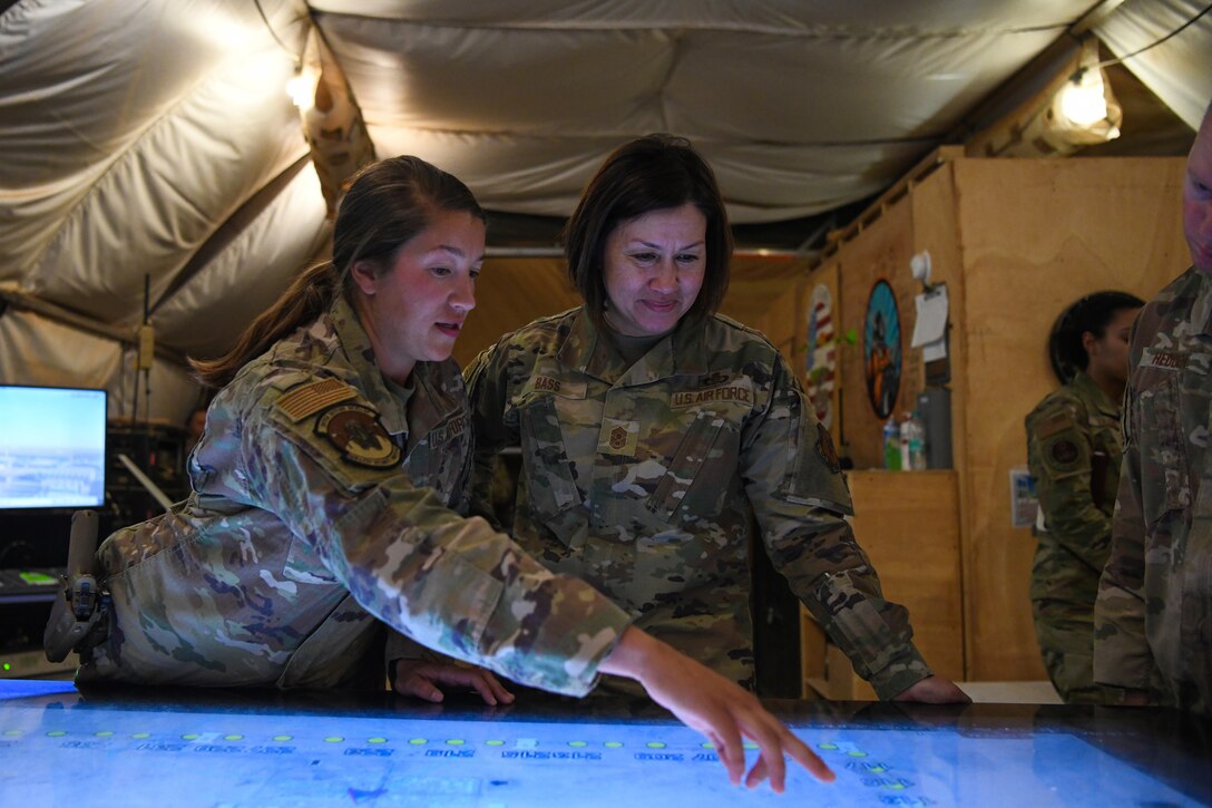 Senior Airman Madison Mortiz, 409th Expeditionary Security Forces Squadron member, briefs Chief Master Sgt. of the Air Force JoAnne S. Bass about the Windows Team Assistance Kit (WinTAK) system at Nigerien Air Base 201, Agadez, Dec. 20, 2021. The WinTAK provides SFS members the ability to have increased situational awareness within the immediate area to ensure continued air operations. (U.S. Air Force photo by Senior Airman Ericka A. Woolever)