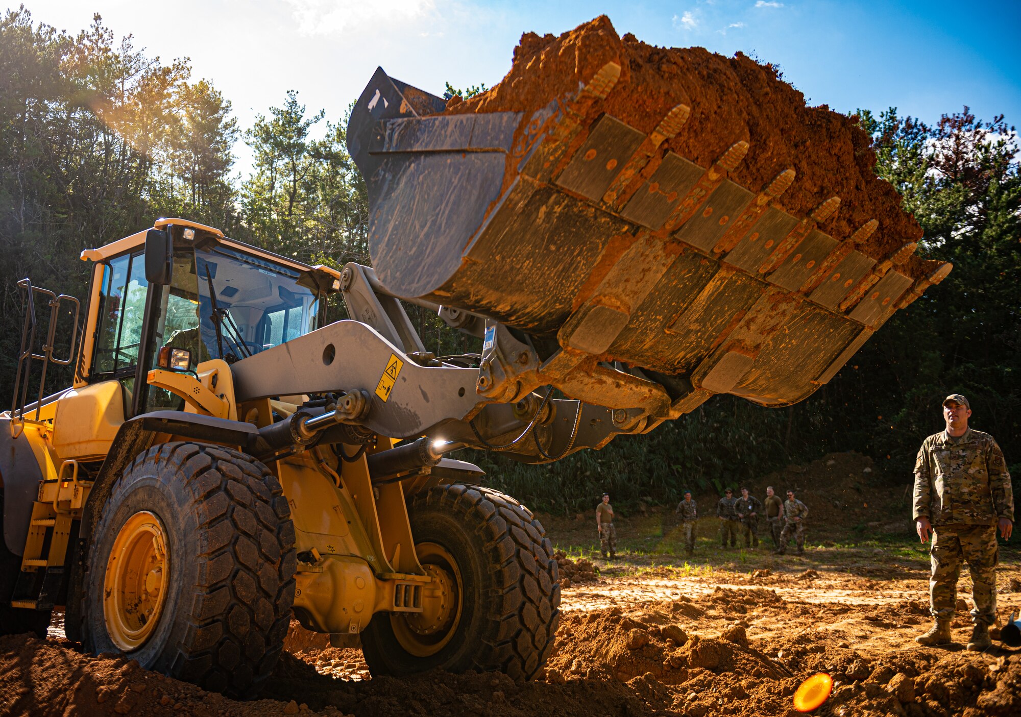 An Airman operates a front end loader.