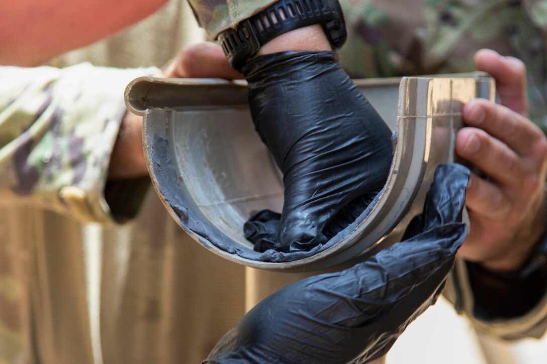 U.S. Army Sgt. 1st Class Shawn Danaher and Sgt. Quinton Banus, both with B Company, 572nd Brigade Engineer Battalion, Task Force Iron Gray, Combined Joint Task Force – Horn of Africa (CJTF-HOA), repair the gutter system at a school in Lamu County, Kenya, Nov. 2, 2021. CJTF-HOA’s efforts as part of a comprehensive whole-of-government approach, are aimed at increasing African partner nations’ capacity to maintain a stable environment, with an effective government that provides a degree of economic and social advancement to its citizens.