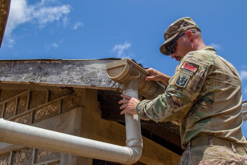 U.S. Army Sgt. 1st Class Shawn Danaher with B Company, 572nd Brigade Engineer Battalion, Task Force Iron Gray, Combined Joint Task Force – Horn of Africa (CJTF-HOA), repairs the gutter system at a school in Lamu County, Kenya, Nov. 2, 2021. CJTF-HOA’s efforts, as part of a comprehensive whole-of-government approach, are aimed at increasing African partner nations’ capacity to maintain a stable environment, with an effective government that provides a degree of economic and social advancement to its citizens.