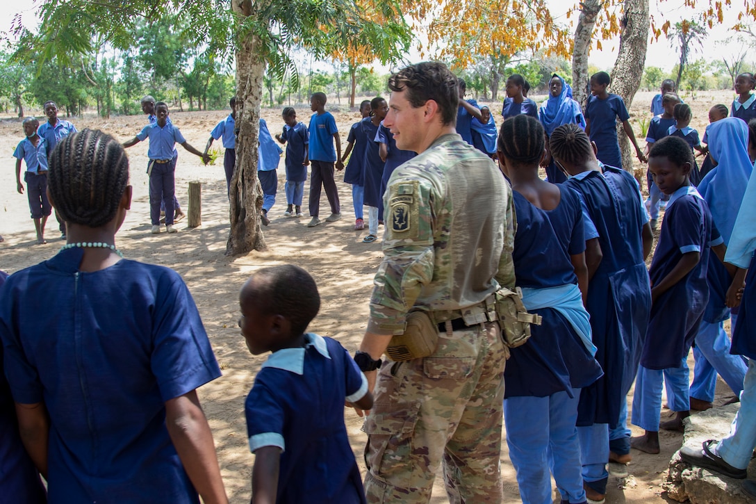 U.S. Army Sgt. Andrew Lerman with Charlie Company, 1-102nd Infantry Regiment (Mountain), Task Force Iron Gray, Combined Joint Task Force – Horn of Africa (CJTF-HOA), participates in a game with students during a cultural engagement at a school in Lamu County, Kenya, Nov. 2, 2021. CJTF-HOA efforts, as part of a comprehensive whole-of-government approach, are aimed at increasing African partner nations’ capacity to maintain a stable environment, with an effective government that provides a degree of economic and social advancement to its citizens.