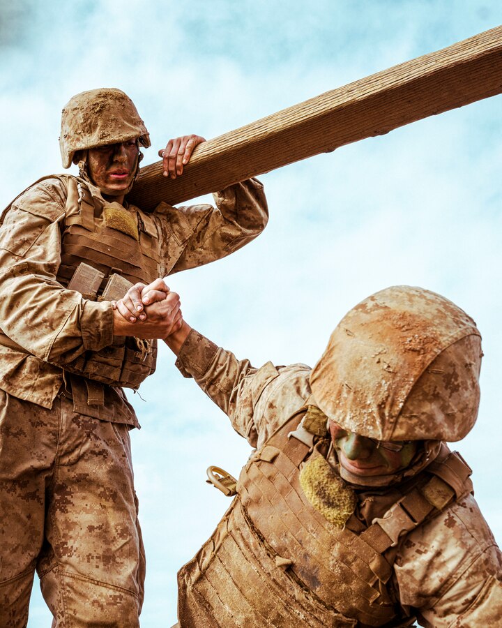 A U.S. Marine Corps recruit with Alpha Company, 1st Recruit Training Battalion, helps his fellow recruit to his feet on an obstacle at Marine Corps Base Camp Pendleton, California, Dec. 29, 2021. This event was a segment of the crucible – the culminating event of recruit training. After completing the crucible’s physically and mentally demanding challenges over the course of 54-hours with limited food and sleep, the recruits will finally have the privilege to call themselves United States Marines. (U.S. Marine Corps photo by Sgt. Christopher A. Madero)