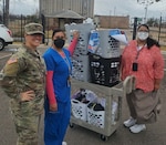 1st Lt. Brittany Dixon, a member of the Oklahoma National Guard Family Program Office, poses with members of the Department of Veterans Affairs employees while donating socks and undergarments collected by Oklahoma National Guard members. The items were collected from Oklahoma National Guard units across the state to be donated to homeless veterans. (Photo provided by Oklahoma National Guard Family Program Office)