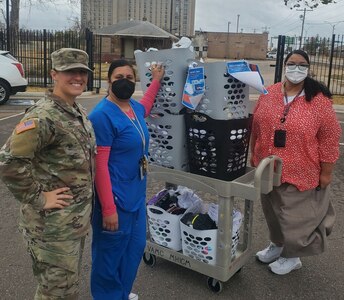 1st Lt. Brittany Dixon, a member of the Oklahoma National Guard Family Program Office, poses with members of the Department of Veterans Affairs employees while donating socks and undergarments collected by Oklahoma National Guard members. The items were collected from Oklahoma National Guard units across the state to be donated to homeless veterans. (Photo provided by Oklahoma National Guard Family Program Office)