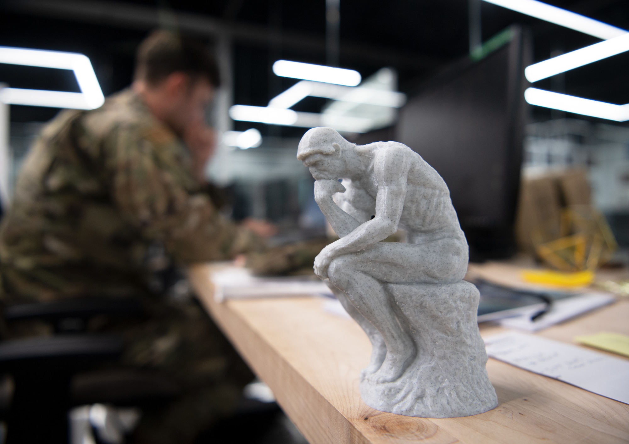 U.S. Air Force Staff Sgt. Nick Cervantes, the noncommissioned officer in charge of FieldWerx project integrations with the 1st Special Operations Wing, as he sits at his desk at the HSU Innovation Institute, near Hurlburt Field, Florida, July 19, 2021. The sculpture was printed using the HSU Innovation Institute’s 3-D printers which have also printed 3-D models of aircraft, design concepts by Airmen and COVID-19 personal protective equipment. (U.S. Air Force photo by Staff Sgt. Sara Voigt)