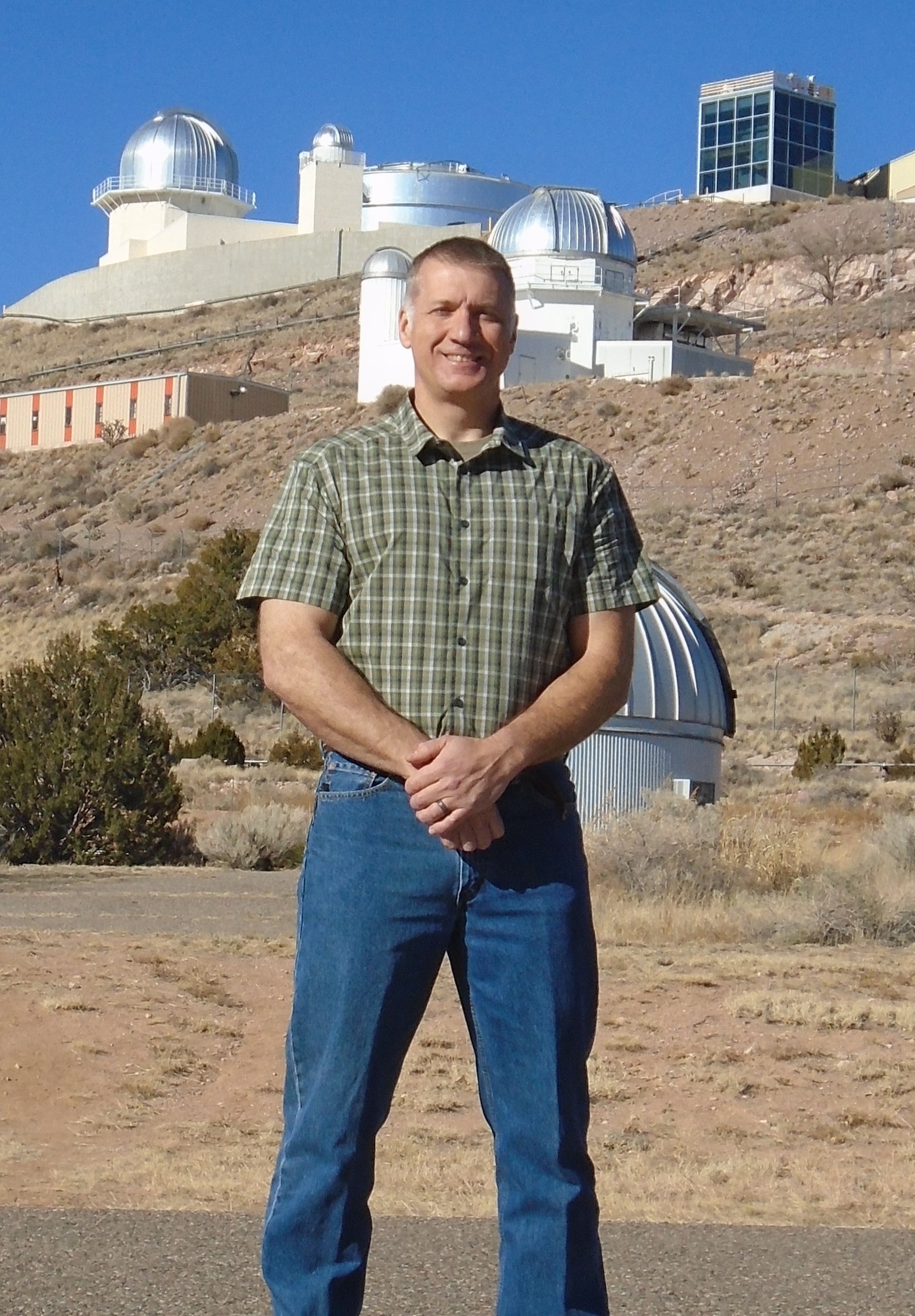 Air Force Research Laboratory senior engineer Dr. Odell Reynolds with AFRL’s Starfire Optical Range telescopes in the background. Odell recorded an image of the asteroid Kalliope and its natural satellite Linus, using AFRL’s1.5 meter telescope on November 29, 2021 – a surprising achievement based on the small diameter of the telescope. (U.S. Air Force photo/Benjamin Herrera)