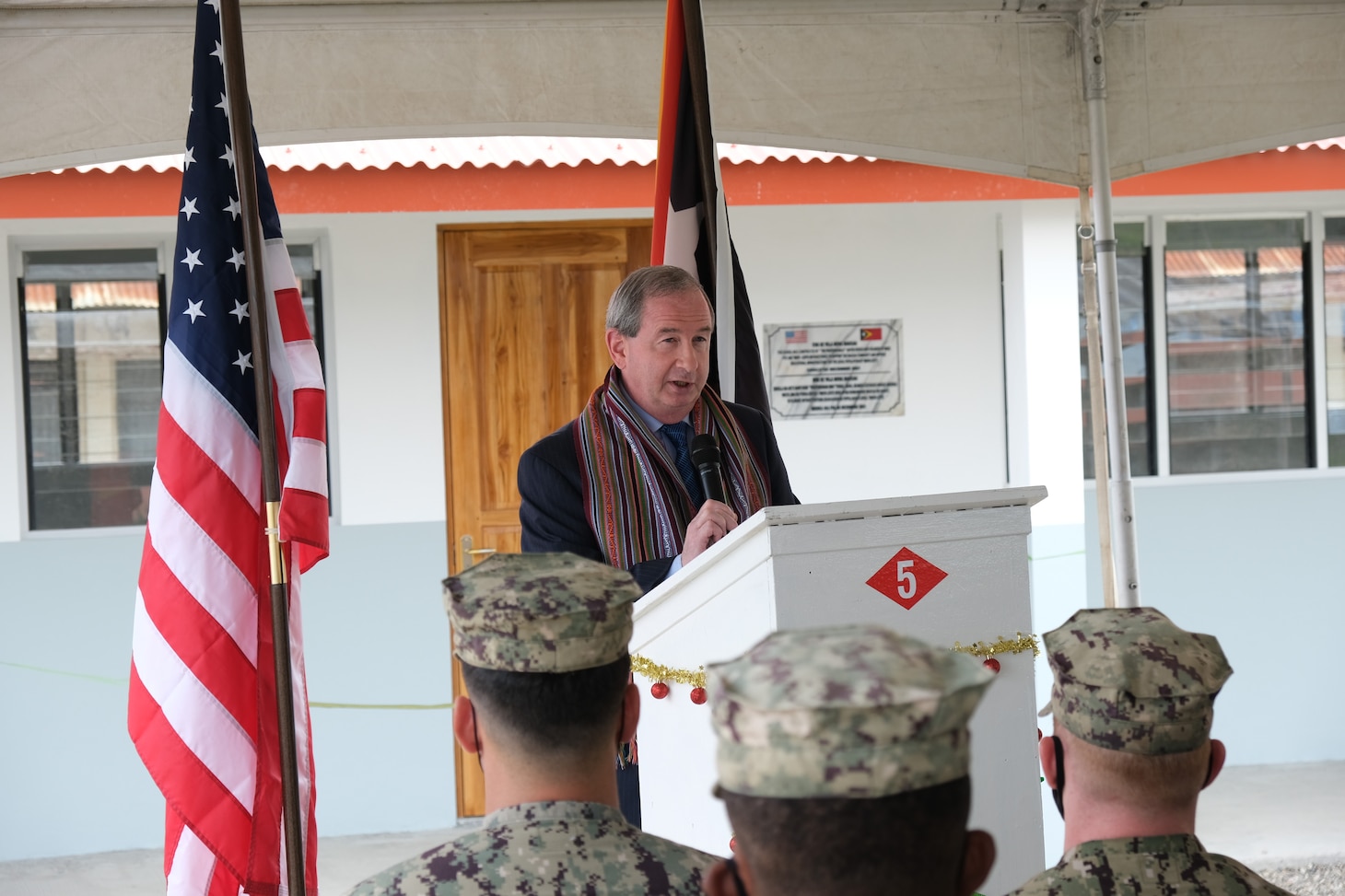 BAUCAU, Timor-Leste (Dec. 10, 2021) Thomas Daley, U.S. Embassy Chargé d’Affairs, speaks to U.S. Navy Seabees with Naval Mobile Construction Battalion (NMCB) 5, the Falintil-Forcas Defensa Timor Leste, and other ministry of education personnel at the ribbon-cutting ceremony of a four-room schoolhouse in Baucau, Timor-Leste. NMCB-5 is deployed to the U.S. 7th Fleet area of operations, supporting a free and open Indo-Pacific, strengthening their alliances and partnerships, and providing general engineering and civil support to joint operational forces. Homeported out of Port Hueneme, California, NMCB-5 has 13 detail sites deployed throughout the U.S. and Indo-Pacific area of operations.