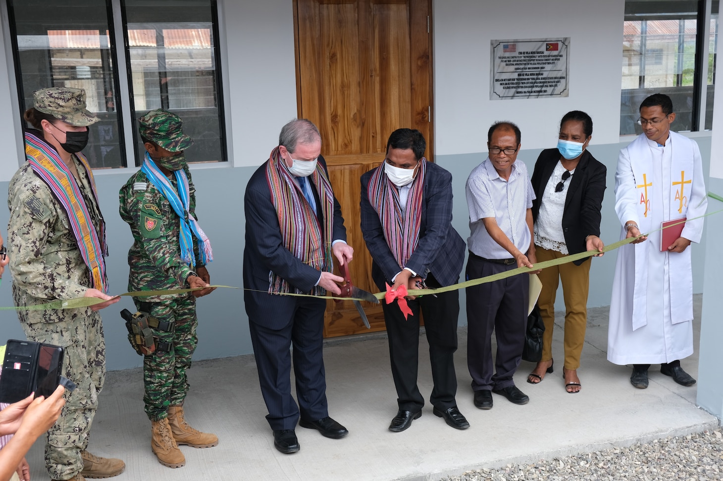 BAUCAU, Timor-Leste (Dec. 10, 2021) Lt. Megan Dunton, with Naval Mobile Construction Battalion (NMCB) 5; Thomas Daley, U.S. Embassy Chargé d’Affairs; and local Timorese leaders cut the ribbon at the completion of the four-room schoolhouse in Baucau, Timor-Leste. The U.S. Navy Seabees with NMCB-5 are deployed to the U.S. 7th Fleet area of operations, supporting a free and open Indo-Pacific, strengthening their alliances and partnerships, and providing general engineering and civil support to joint operational forces. Homeported out of Port Hueneme, California, NMCB-5 has 13 detail sites deployed throughout the U.S. and Indo-Pacific area of operations.