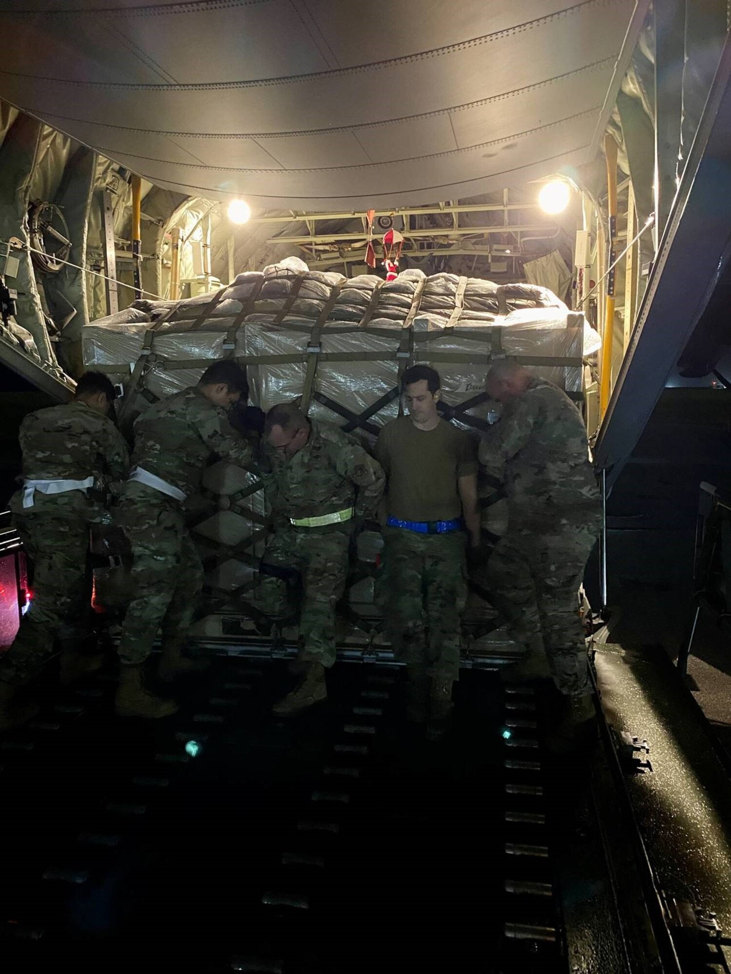 Airmen from the 36th Logistics Readiness Squadron push a Reverse Osmosis Water Purification Unit onto a C-130J out of Yokota Air Force Base at Andersen Air Force Base, December 15th, 2021. The unit was quickly delivered to Wake Island after their water purifier malfunctioned, leaving the atoll without potable water. (U.S. Air Force photo by Capt. Kenny Maeng)