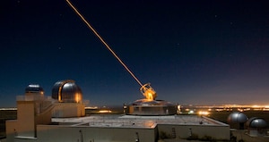 AFRL’s 3.5 meter telescope on Kirtland AFB, N.M. uses its laser to produce a guide star for a reference for adaptive optics, and previously held the record for the smallest telescope to image an asteroid’s satellite. The larger of the two domes to its left houses the 1.5 meter telescope, which now holds the record, without using a laser. (US Air Force photo/Robert Fugate)