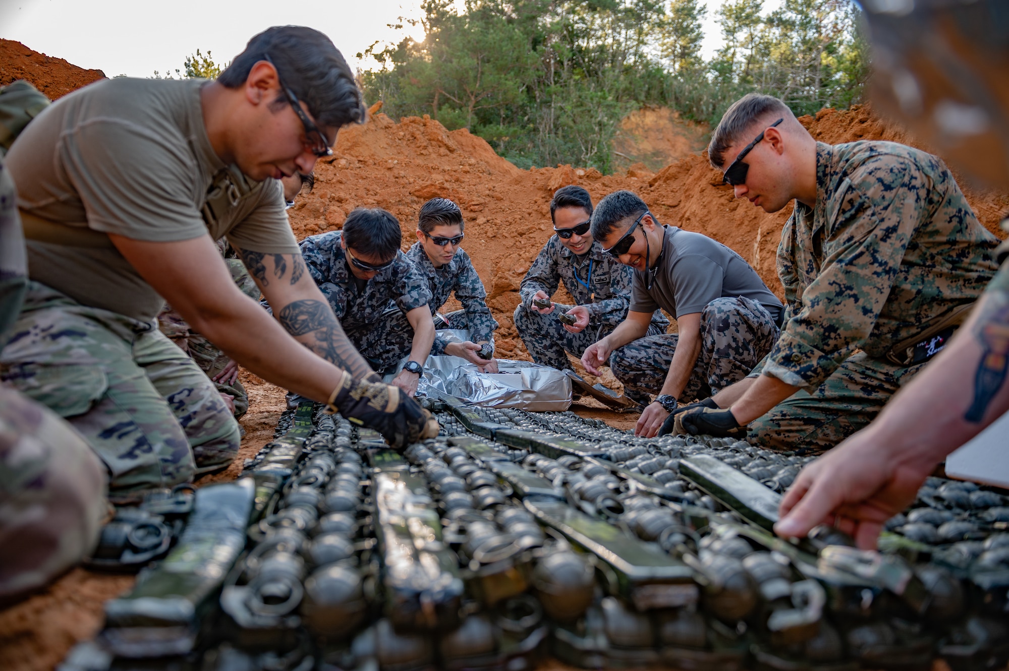 U.S. Airmen, Marines and Japan Air Self-Defense Force members prepare grenades for disposal.