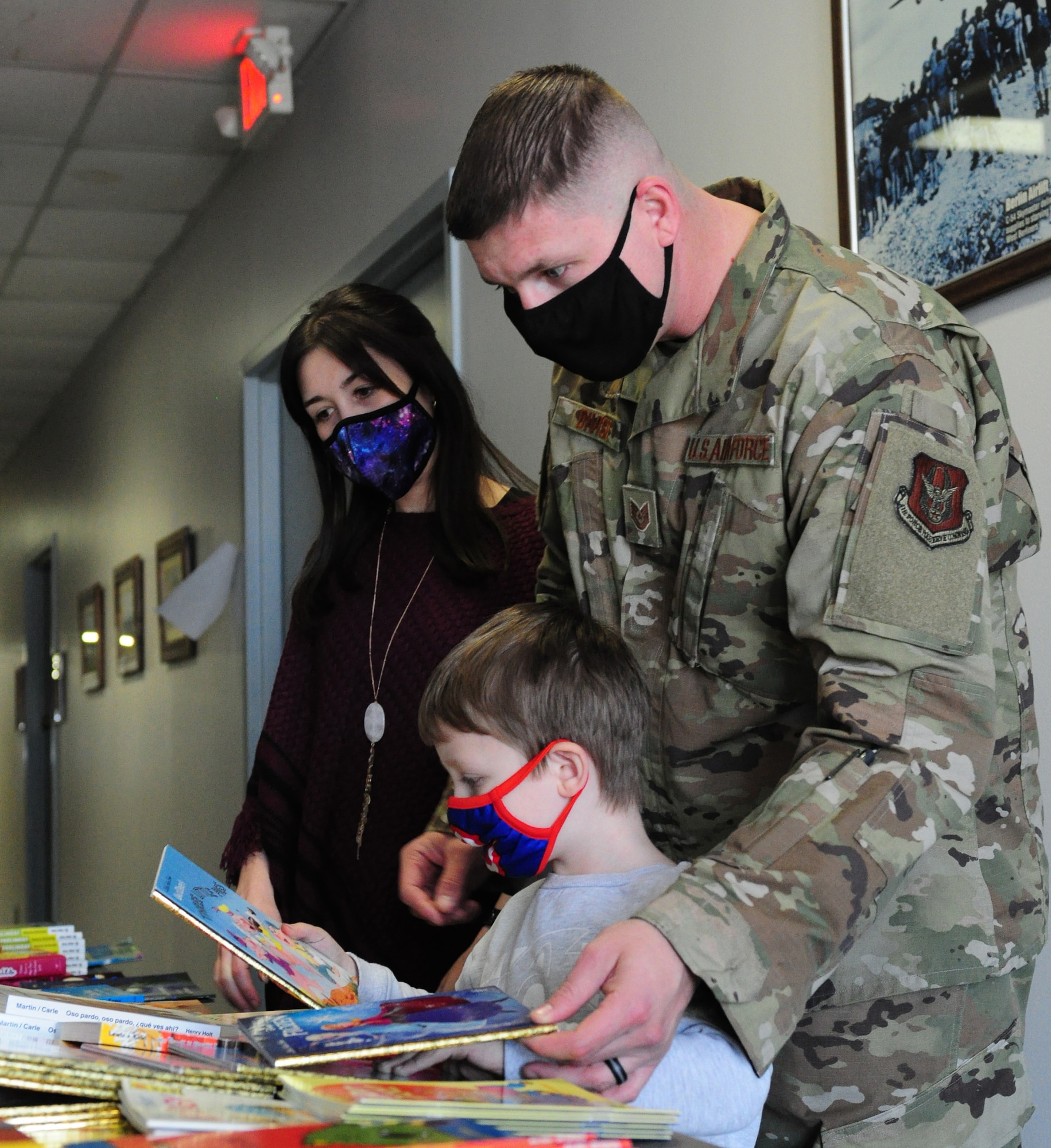 Tech. Sgt. Joseph Divish, 87th Aerial Port Squadron, and his wife, Destinee Divish, help their son, Deklan, choose from a selection of new children’s books provided by the United Service Organizations through the Bob Hope Legacy Reading Program, Nov. 7, 2021. A USO volunteer recorded a video of the family reading the book so Deklan can watch it later while his dad is deployed. The 87th APS hosted two comprehensive pre-deployment days for the squadron’s families at Wright-Patterson Air Force Base, Ohio.