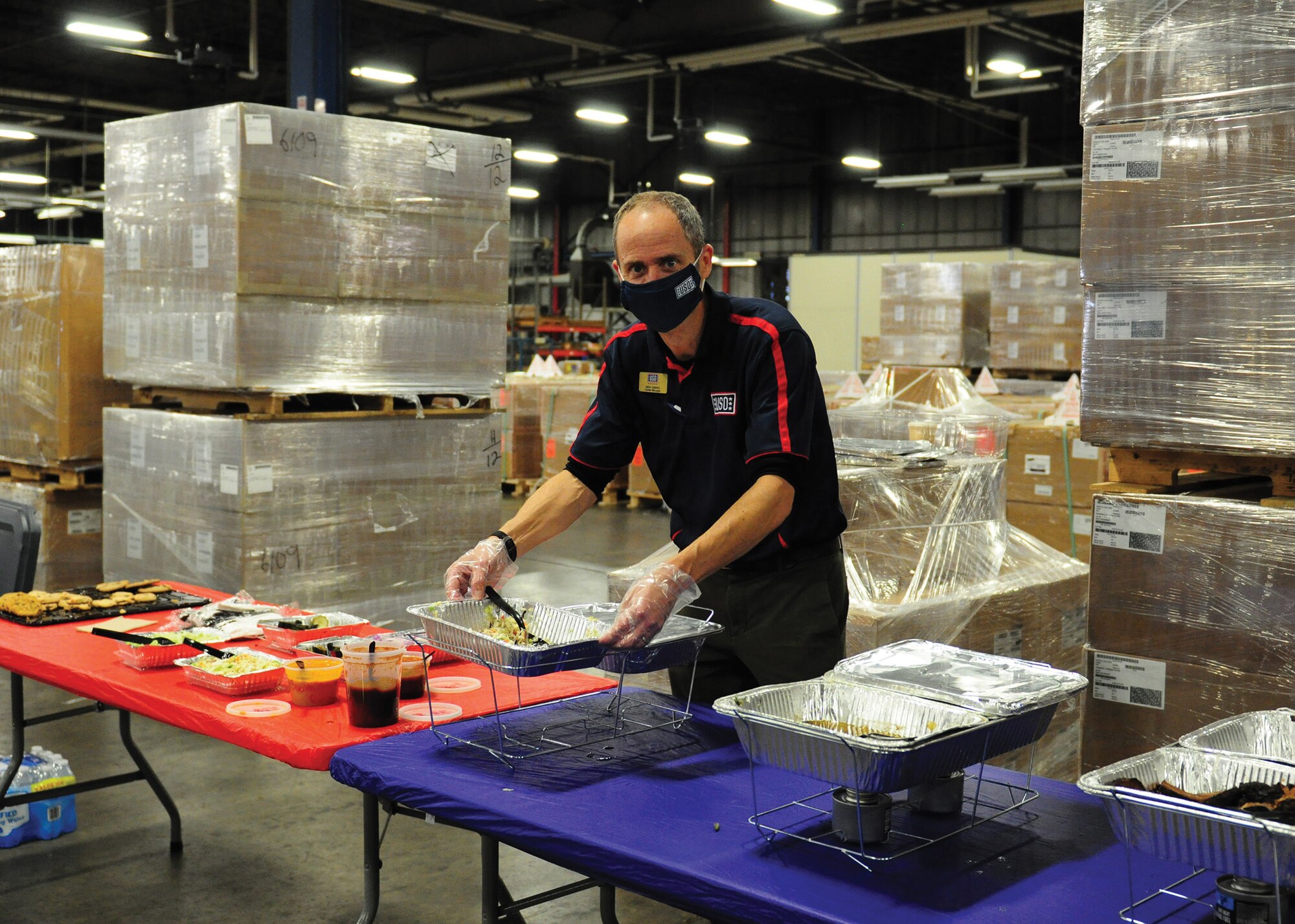 Erik Oberg, center manager of the Wright-Patterson Air Force Base United Service Organizations, serves lunch during a, 87th Aerial Port Squadron pre-deployment family event Nov. 7, 2021. Oberg and USO volunteers brought books, toys, care packages, and handwritten notes from NFL Cincinnati Bengals’ team members to Airmen in the unit and their families.