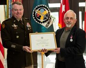 Maj. Gen. Chris Mohan, commanding general, U.S. Army Sustainment Command, presents a Certificate of Retirement to Carl Cartwright, executive director for Acquisition, Integration and Management, ASC, at Rock Island Arsenal, Illinois, Dec. 22. Cartwright retired with 43 years of combined military and civilian service.