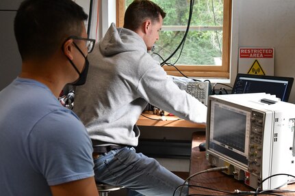 IMAGE: Naval Surface Warfare Center Dahlgren Division Statistician Nhan Bui supports scientist Thomas Salvato as the pair work on vessel stopping efforts using high powered microwave technologies.