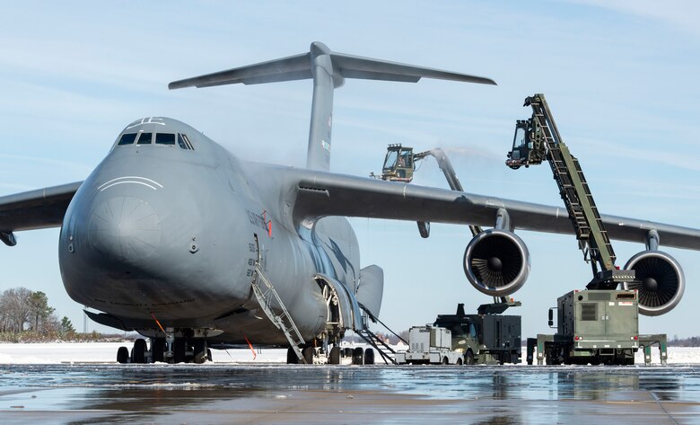 Team Dover aircraft maintainers remove snow and ice from a C-5M Super Galaxy on the flight line at Dover Air Force Base, Delaware, Jan. 4, 2022. After Winter Storm Frida dropped eight inches of snow, base personnel worked diligently to resume normal operations. (U.S. Air Force photo by Roland Balik)