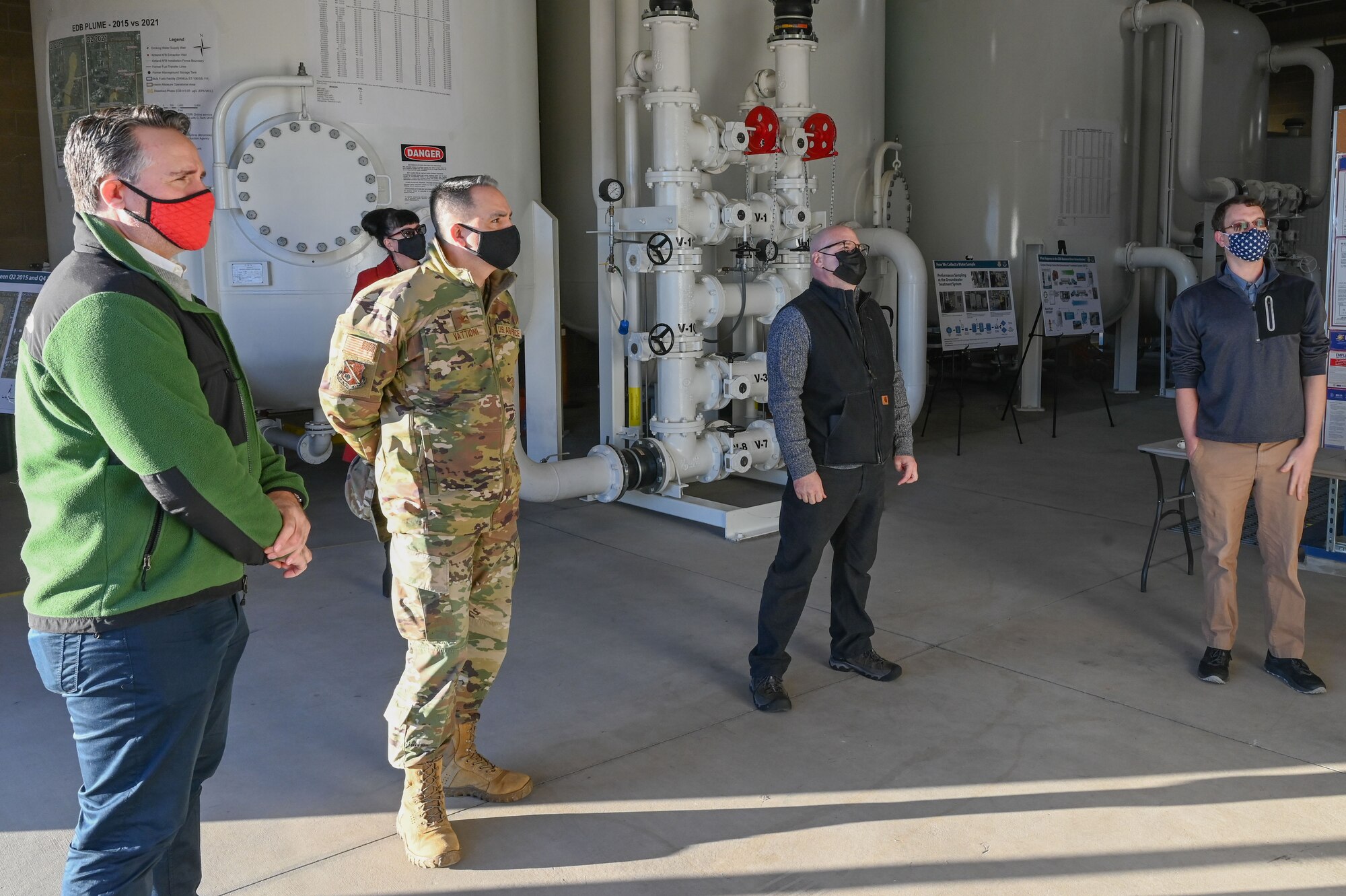 Four men look at a water treatment system.