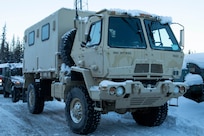 A Light Medium Tactical Vehicle and a High Mobility Multipurpose Wheeled Vehicle warm up at the Alaska National Guard Armory on Joint Base Elmendorf-Richardson, Alaska, prior to transport to Alcantra Armory in Wasilla, Jan. 5. The LMTV and HMMWV have been assigned to Alaska Army National Guard's 297th Regional Support Group to provide direct support to the Matsu-Borough after high winds have led to infrastructure damage, power outages, and dangerous transportation conditions. (U.S. Army National Guard photo by Victoria Granado)