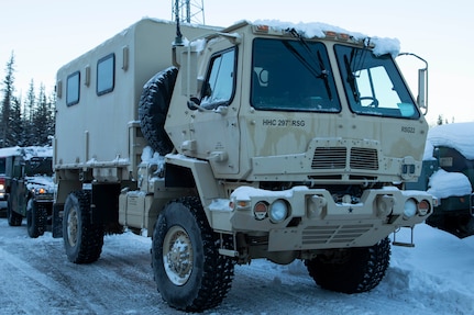 A Light Medium Tactical Vehicle and a High Mobility Multipurpose Wheeled Vehicle warm up at the Alaska National Guard Armory on Joint Base Elmendorf-Richardson, Alaska, prior to transport to Alcantra Armory in Wasilla, Jan. 5. The LMTV and HMMWV have been assigned to Alaska Army National Guard's 297th Regional Support Group to provide direct support to the Matsu-Borough after high winds have led to infrastructure damage, power outages, and dangerous transportation conditions. (U.S. Army National Guard photo by Victoria Granado)