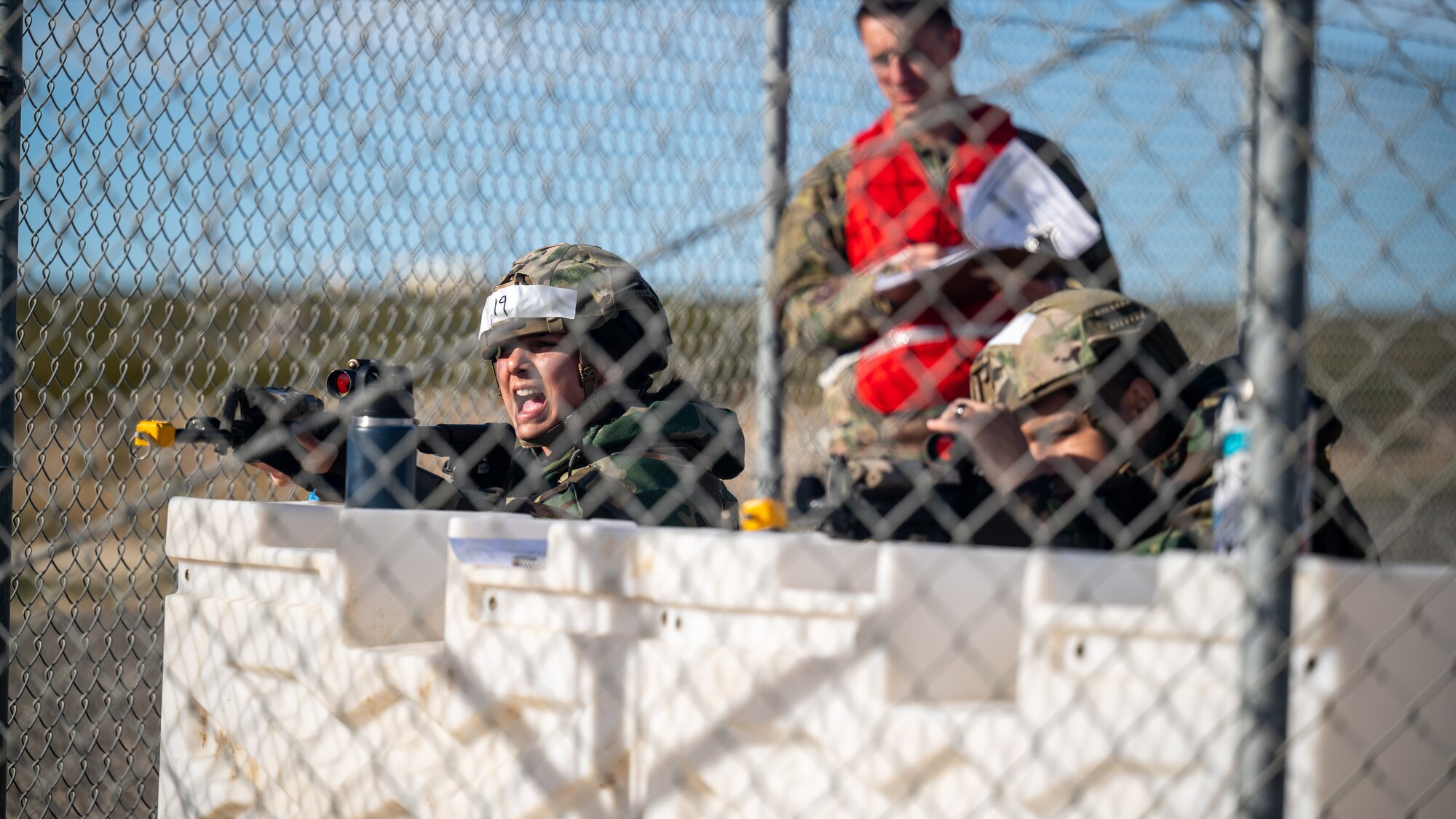 Staff Sgt. Emily Cates, 412th Security Forces Squadron, yells out commands to suspected enemy combatants while Airman 1st Class Josue Sanchez-Galvan, also from 412th SFS, keeps guard during a deployment exercise on Edwards Air Force Base, California, Dec. 2. (Air Force photo by Giancarlo Casem)