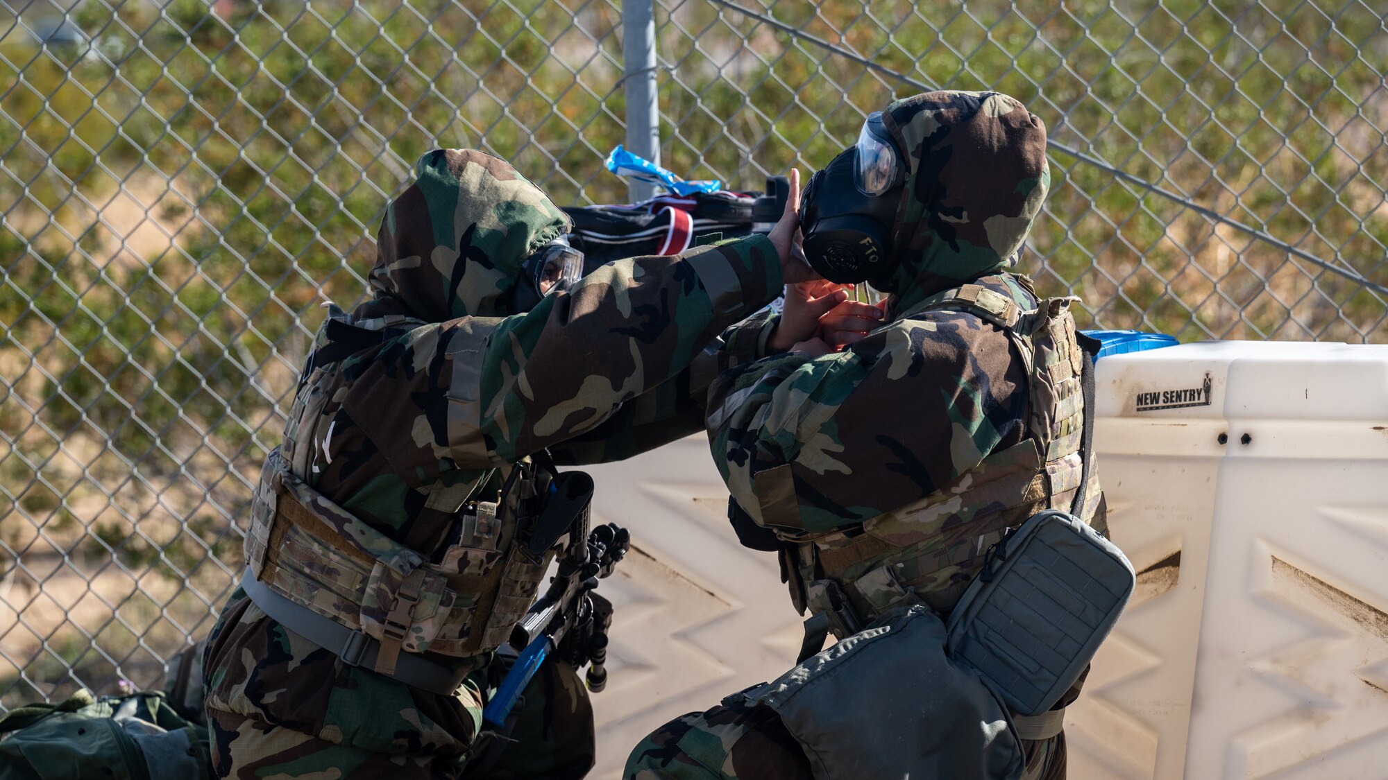 Staff Sgt. Emily Cates, and Airman 1st Class Josue Sanchez-Galvan, both from 412th Security Forces Squadron, don protective equipment during a deployment exercise on Edwards Air Force Base, California, Dec. 2. (Air Force photo by Giancarlo Casem)