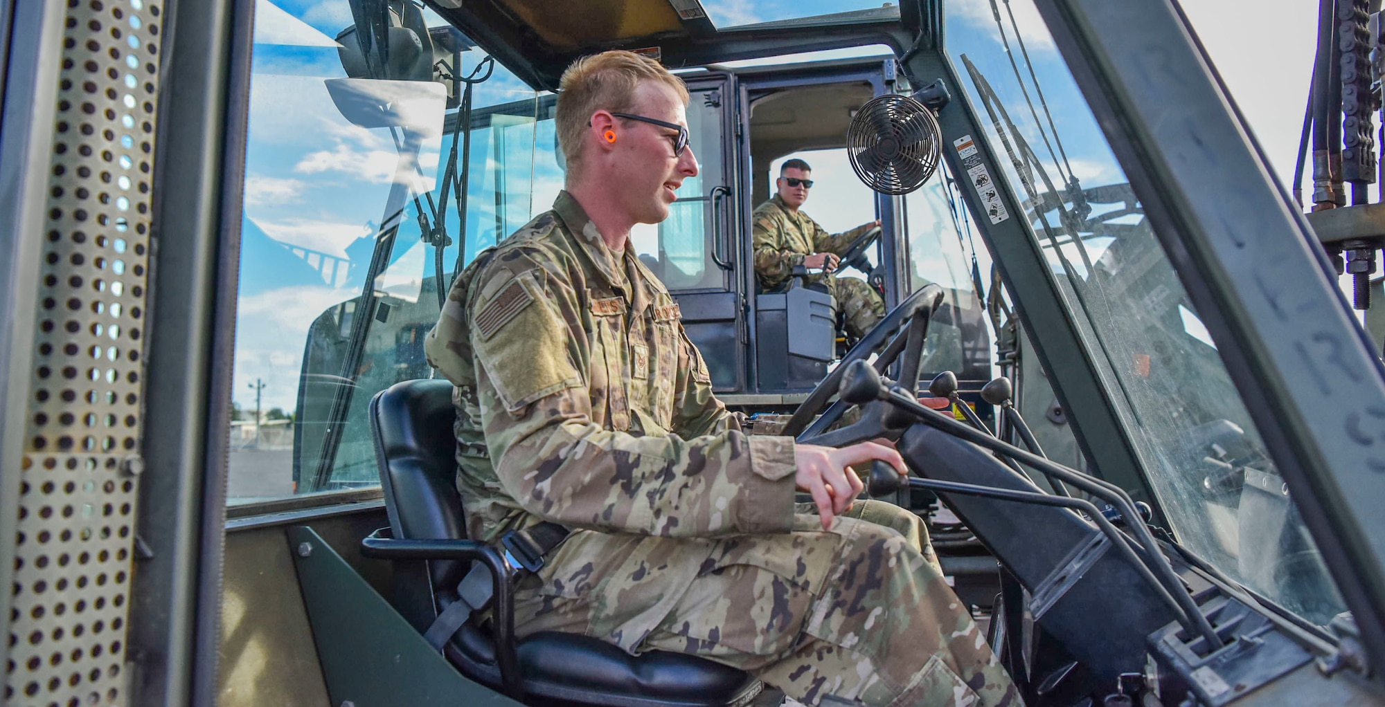 U.S. Air Force Staff Sgt’s. Austin Chambers and Kevin Mcgauley, 647th Logistics Readiness Squadron members discuss forklift procedures within the cargo deployment function yard at Joint Base Pearl Harbor-Hickam, Hawaii, Dec. 22, 2021. 647th LRS received a total of 15 pallets of charcoal filters weighing 75 tons from a C-5 Super Galaxy in support of the water recovery efforts on Oahu.   (U.S. Air Force photo by Tech. Sgt. Anthony Nelson Jr.)