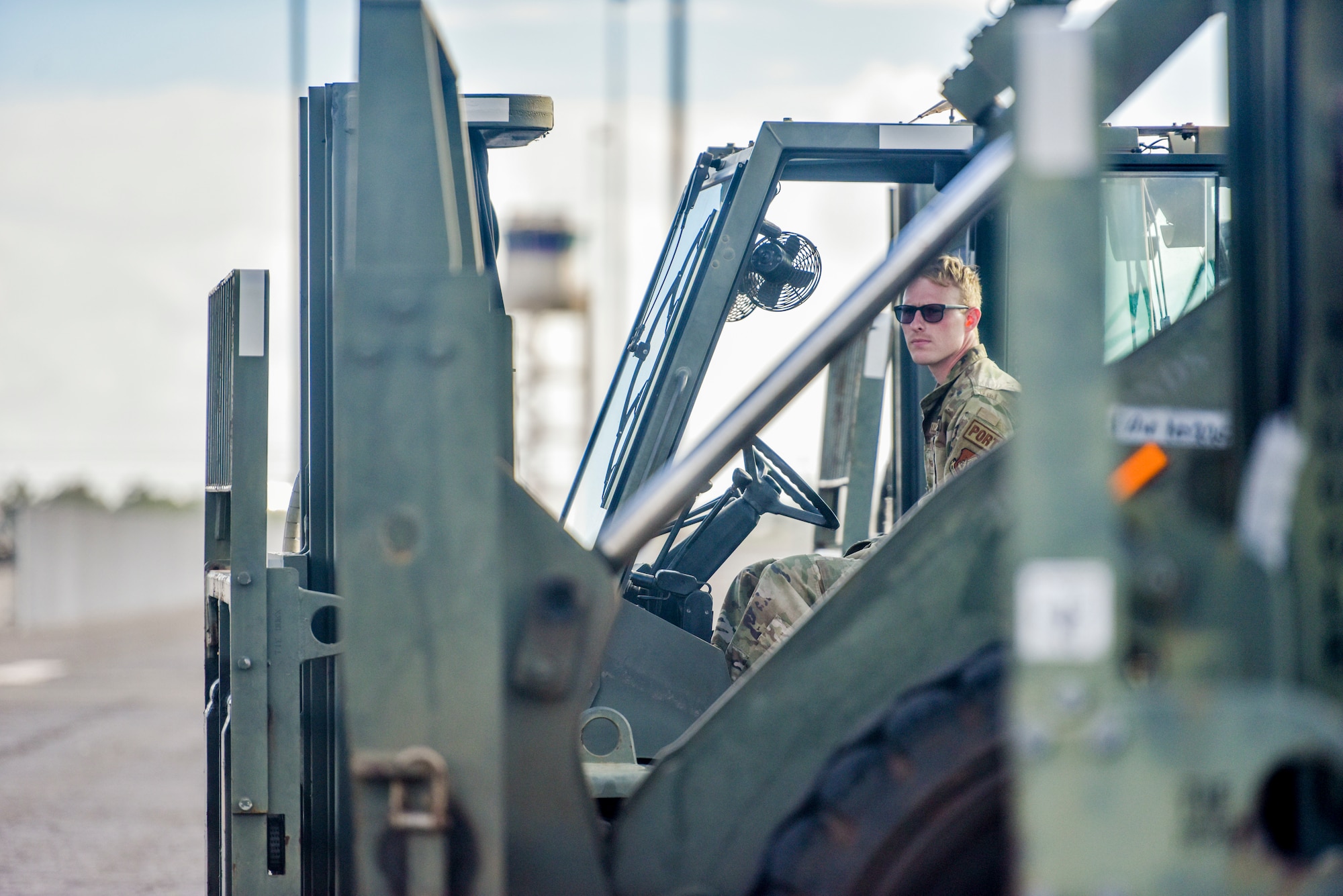 U.S. Air Force Staff Sgt’s. Austin Chambers and Kevin Mcgauley, 647th Logistics Readiness Squadron members discuss forklift procedures within the cargo deployment function yard at Joint Base Pearl Harbor-Hickam, Hawaii, Dec. 22, 2021. 647th LRS received a total of 15 pallets of charcoal filters weighing 75 tons from a C-5 Super Galaxy in support of the water recovery efforts on Oahu.   (U.S. Air Force photo by Tech. Sgt. Anthony Nelson Jr.)