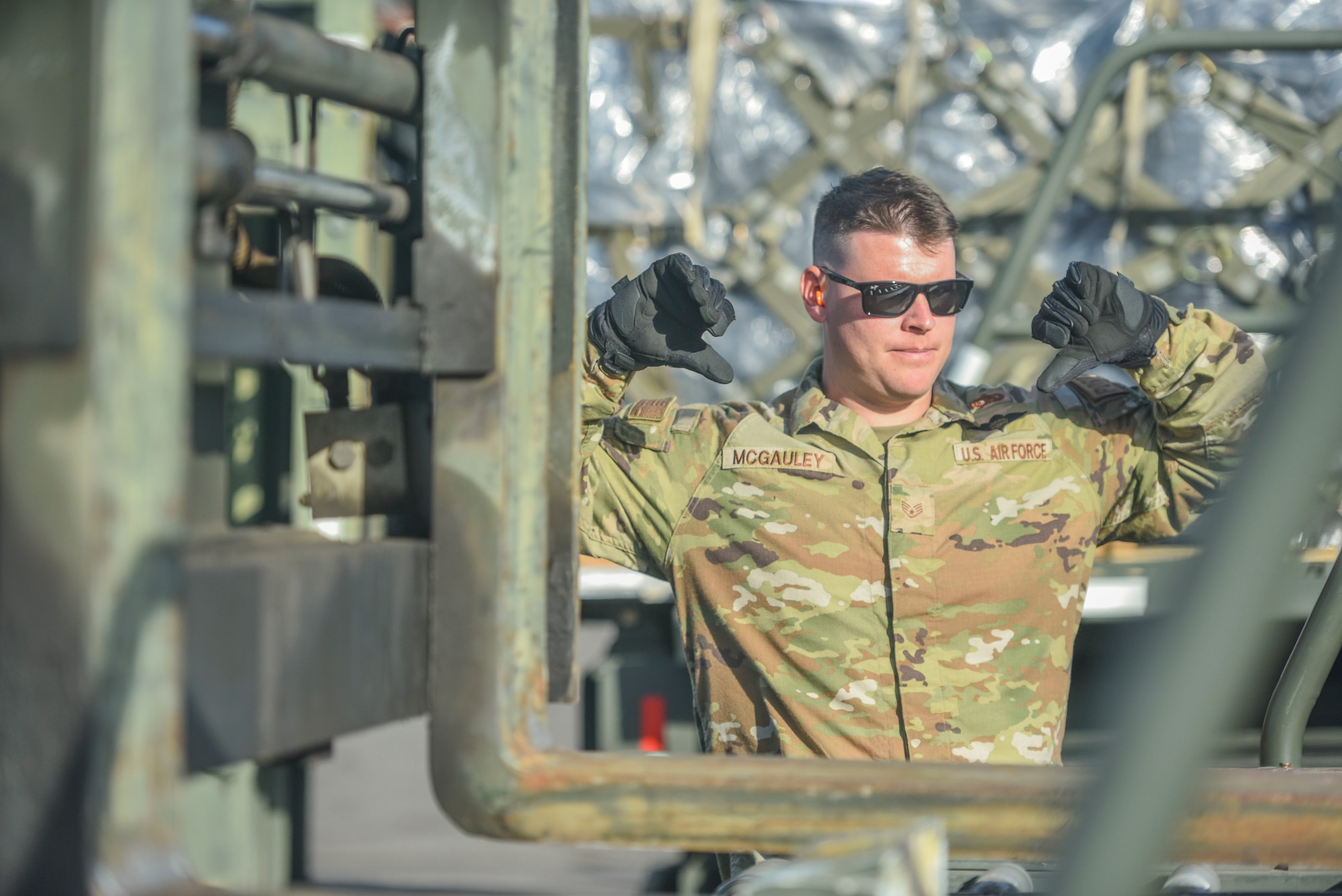 U.S. Air Force Staff Sgt. Kevin Mcgauley, 647th Logistics Readiness Squadron combat mobility flight team chief, spots a forklift driver at Joint Base Pearl Harbor-Hickam, Hawaii, Dec. 22, 2021. 647th LRS recieved a total of 15 pallets of charcoal filters weighing 75 tons in support of the water recovery efforts on Oahu.   (U.S. Air Force photo by Tech. Sgt. Anthony Nelson Jr.)