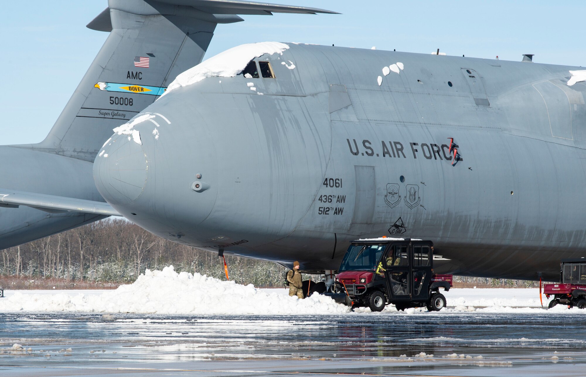 Team Dover maintainers move snow away from a C-5M Super Galaxy at Dover Air Force Base, Delaware, Jan. 4, 2022. After Winter Storm Frida dropped eight inches of snow, base personnel worked diligently to resume normal operations. (U.S. Air Force photo by Roland Balik)