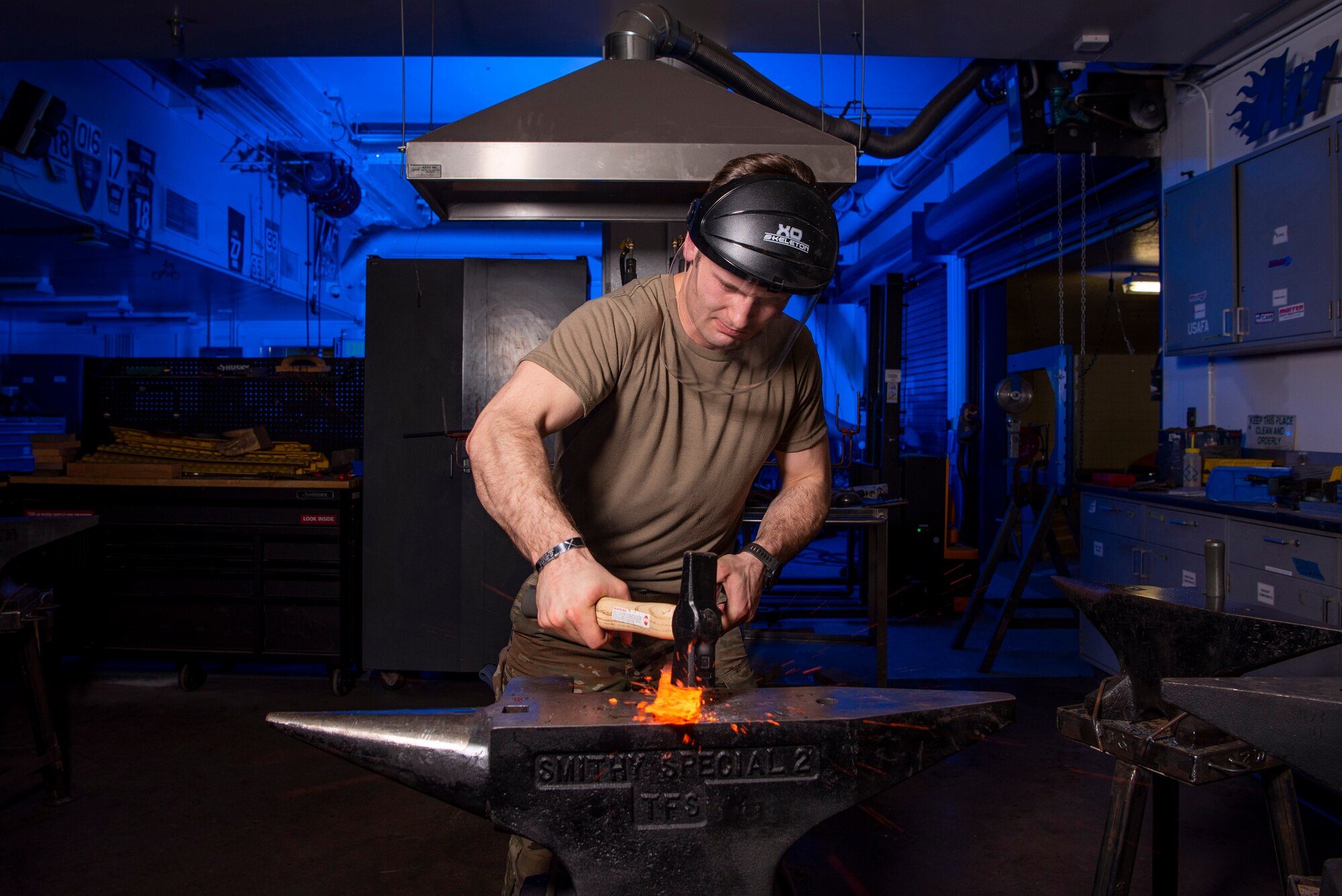 A Cadet shapes a piece of hot steel into a knife