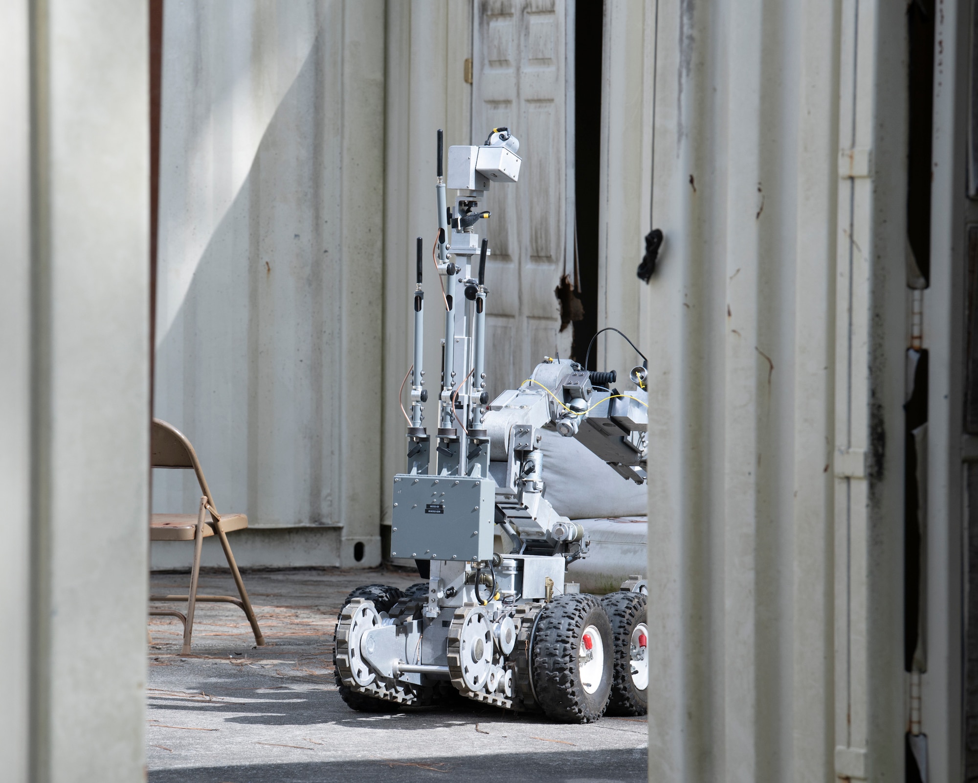 A Romotec ANDROS F6A robot enters a room during an IED training scenario.