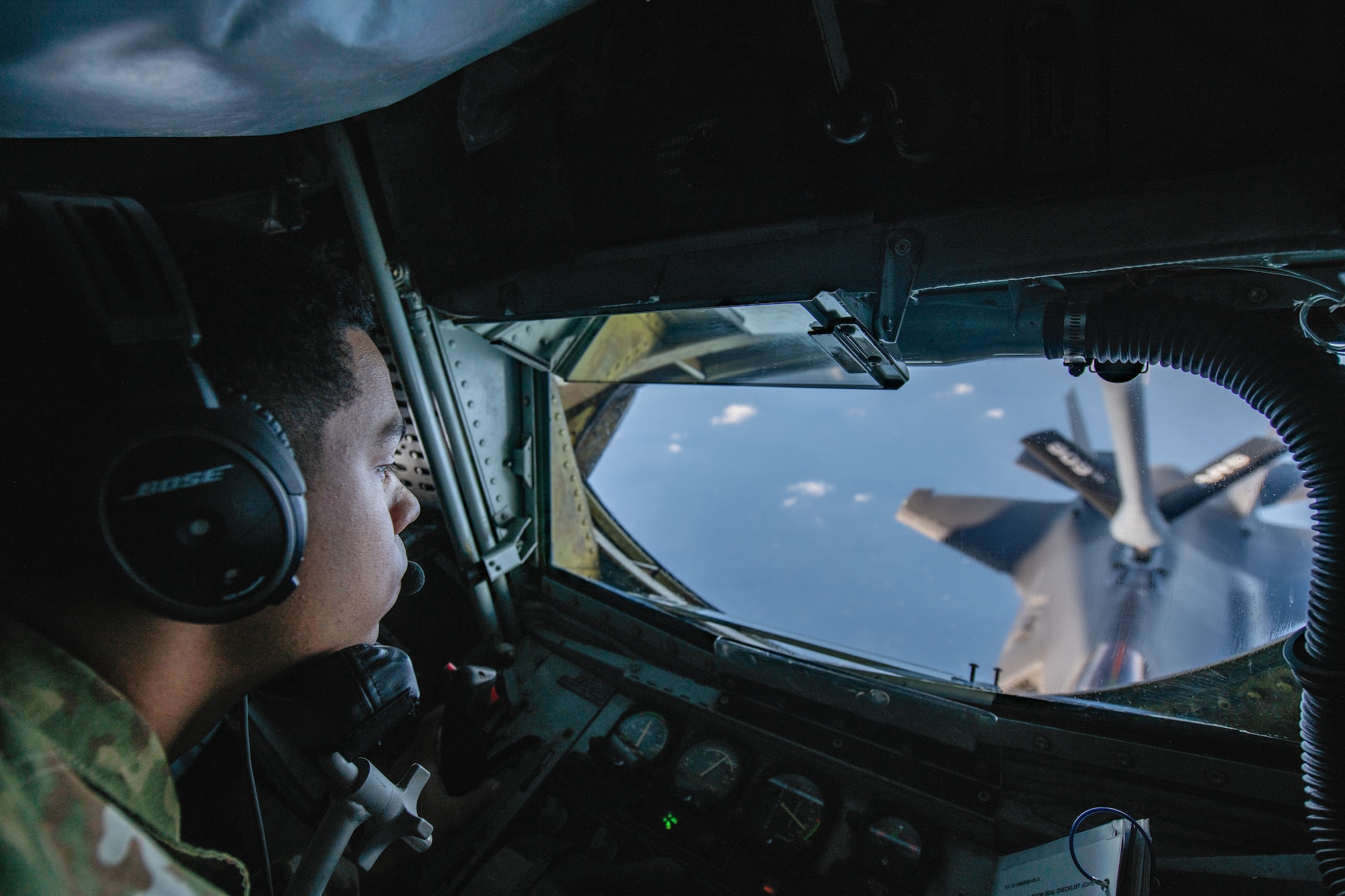 An Airman watches as he refuels a fighter jet