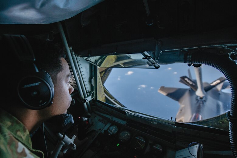 An Airman watches as he refuels a fighter jet