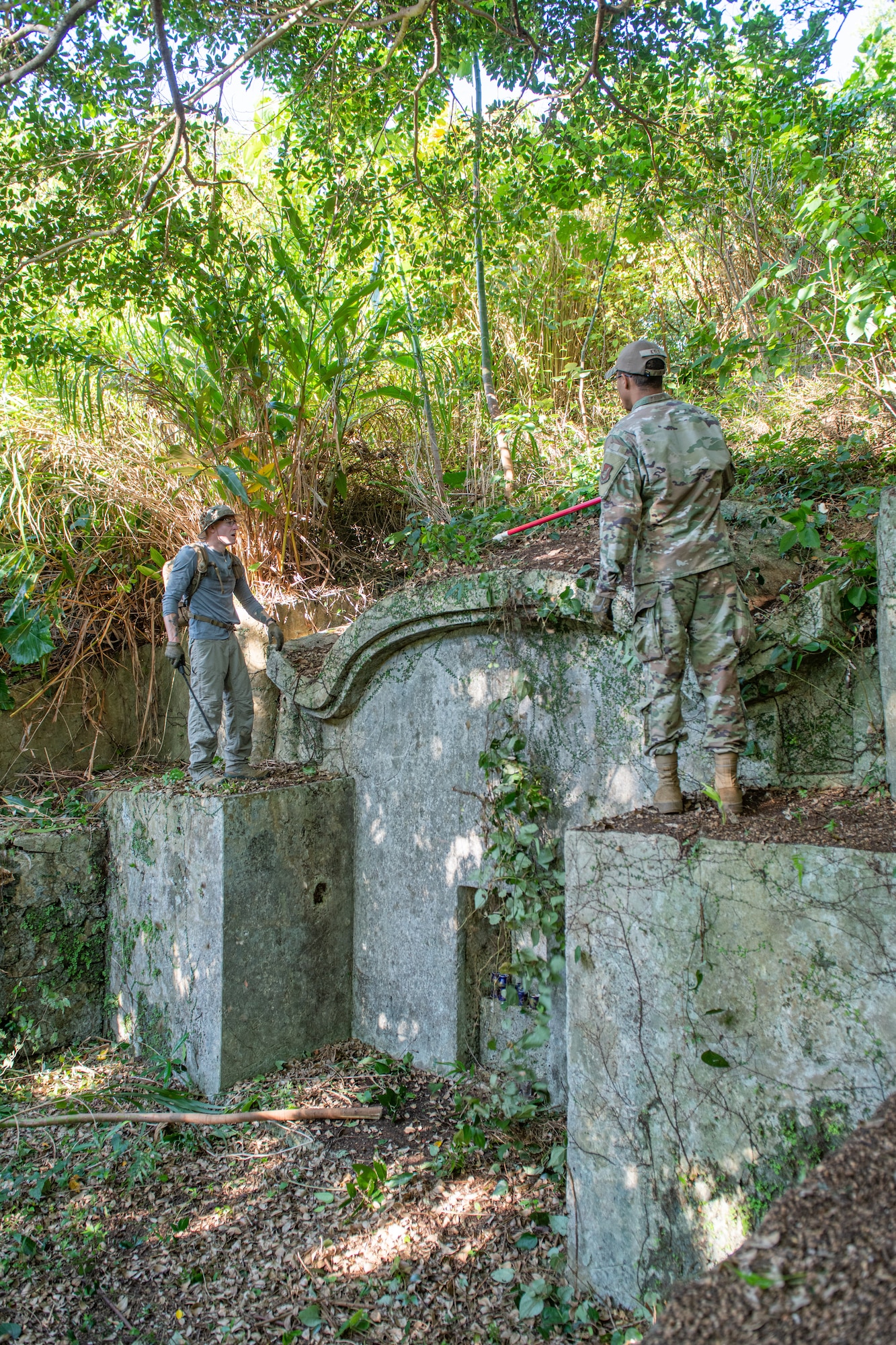 Two Airmen talk to each other next to a shrine